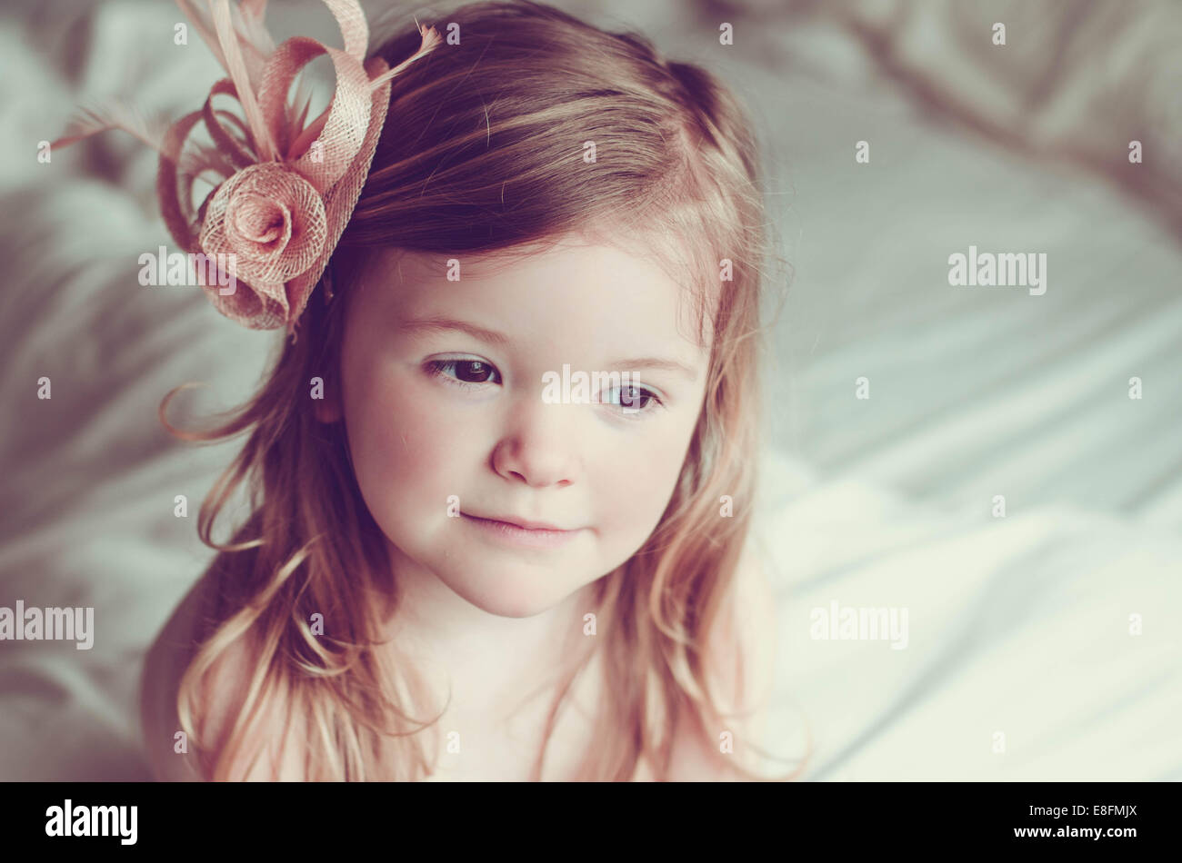 Portrait d'une fille assise sur un lit portant un biateur Banque D'Images