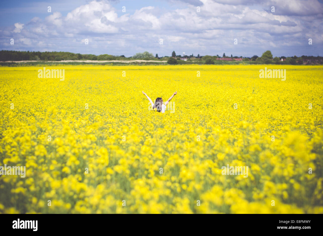 Girl standing in rapeseed field Banque D'Images