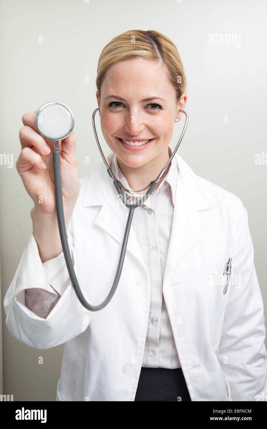 Portrait d'une femme souriante médecin tenant un stéthoscope Banque D'Images