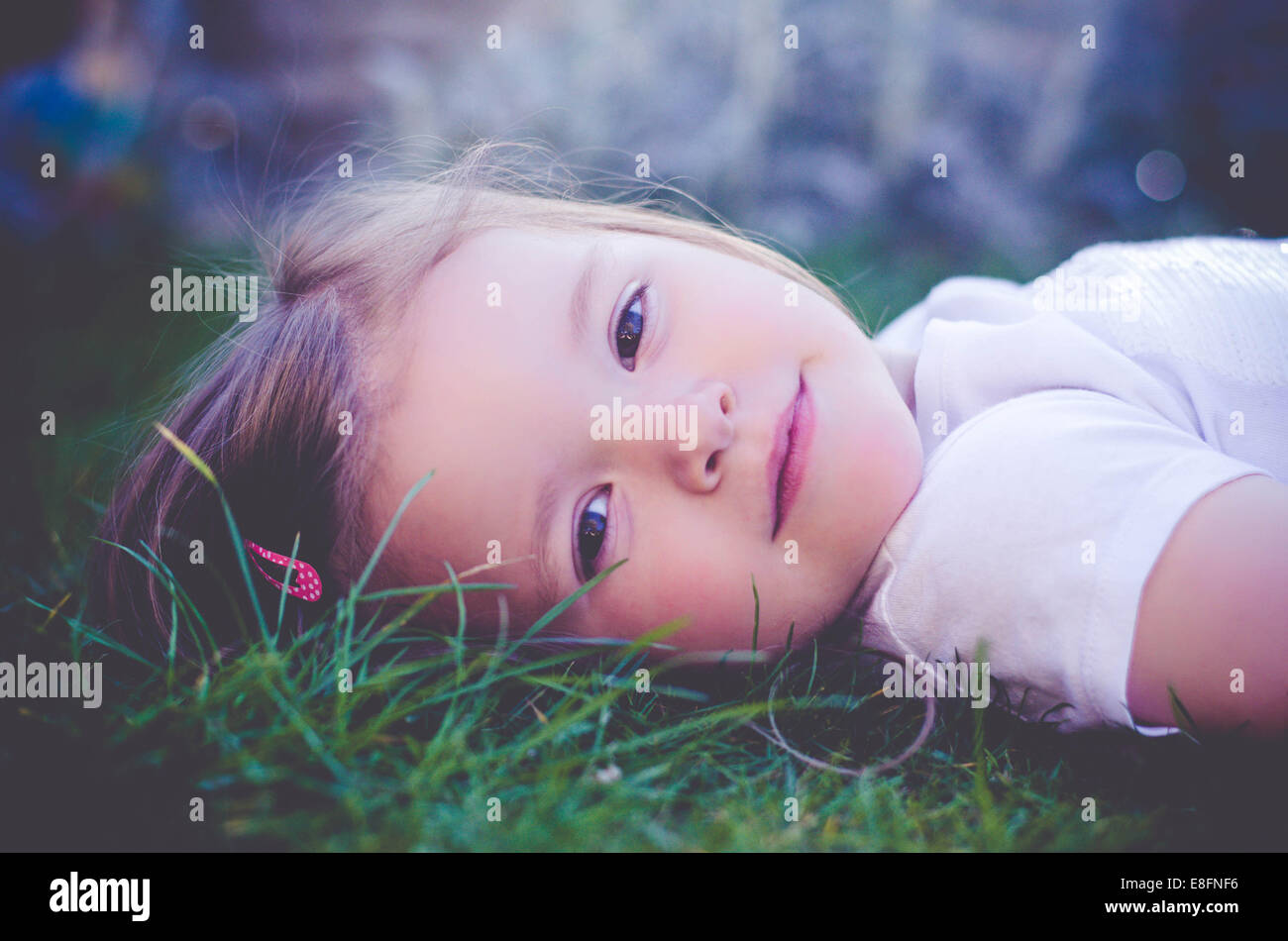 Portrait of a smiling girl lying on grass Banque D'Images