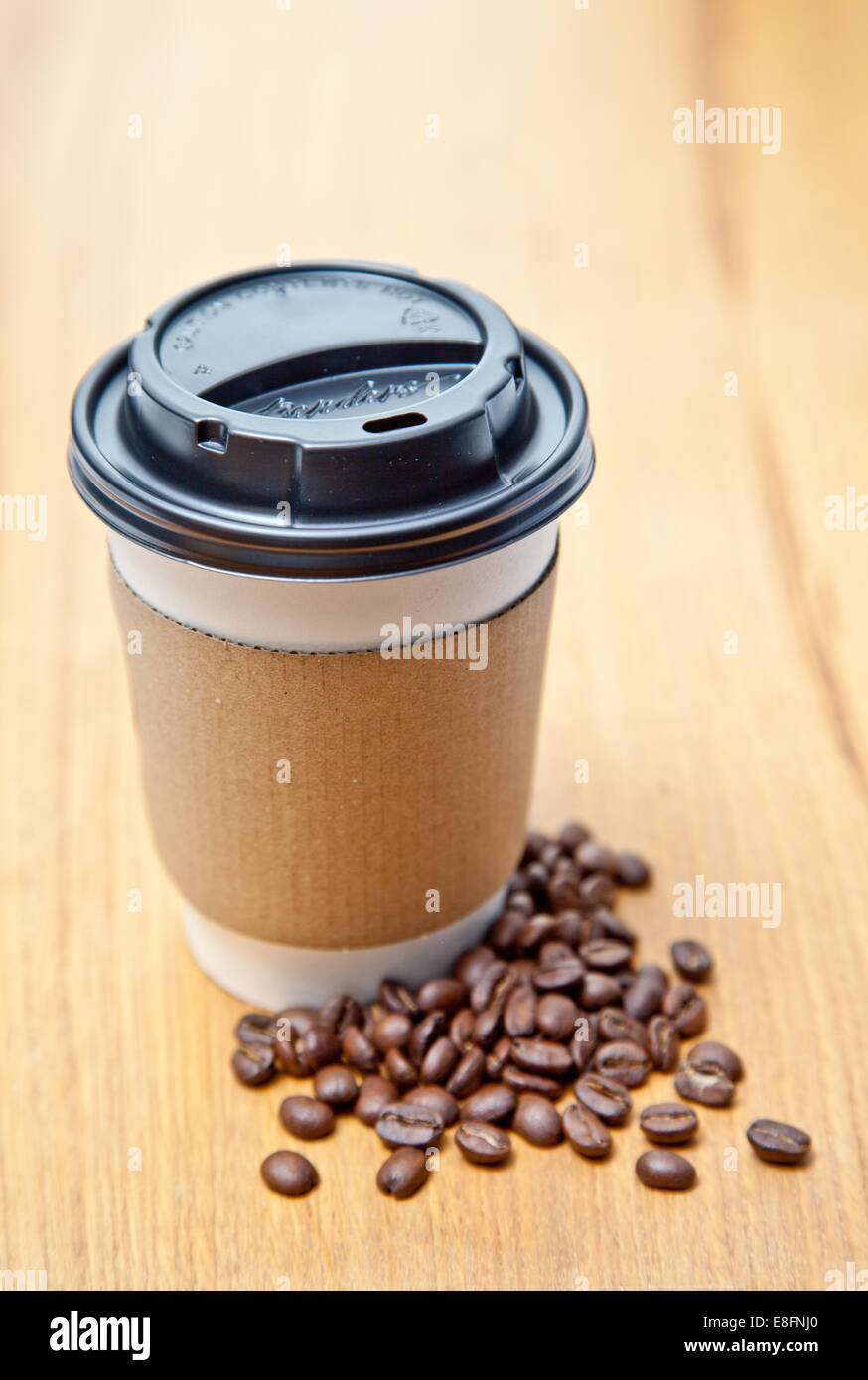Tasse à café jetable et les grains de café sur la table Banque D'Images