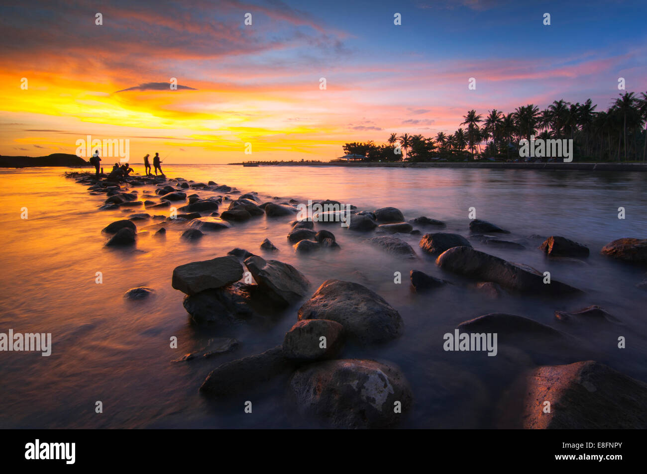 L'Indonésie, Sumatra, l'Ouest de Sumatra, Silhouette de personnes sur la plage au coucher du soleil Banque D'Images