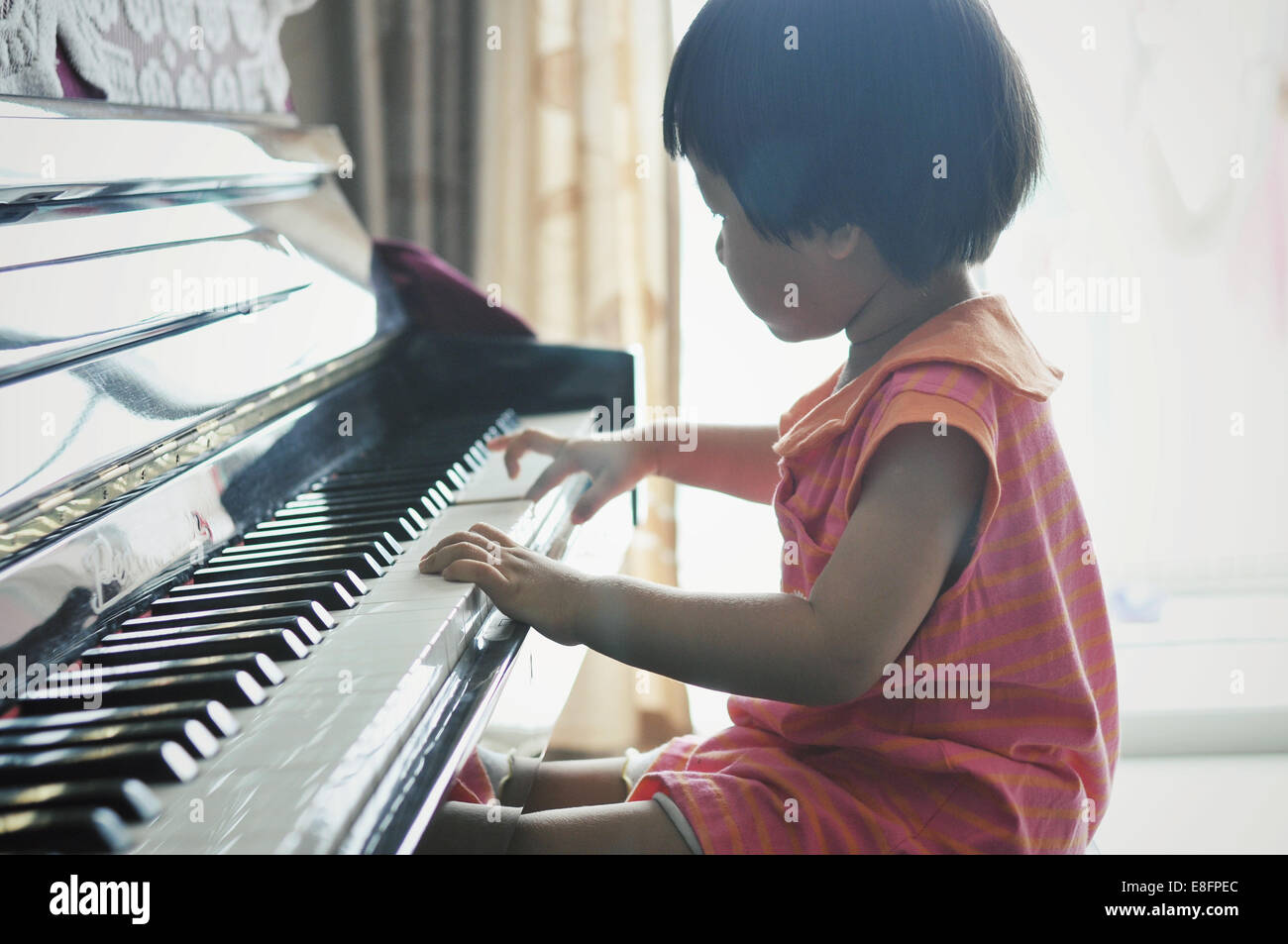 Jeune fille (2-3) playing piano Banque D'Images