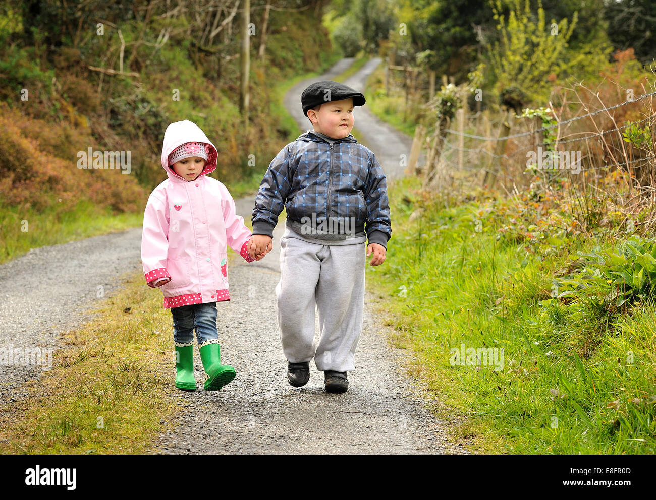 Garçon et fille marchant le long d'un sentier de pied tenant les mains Banque D'Images