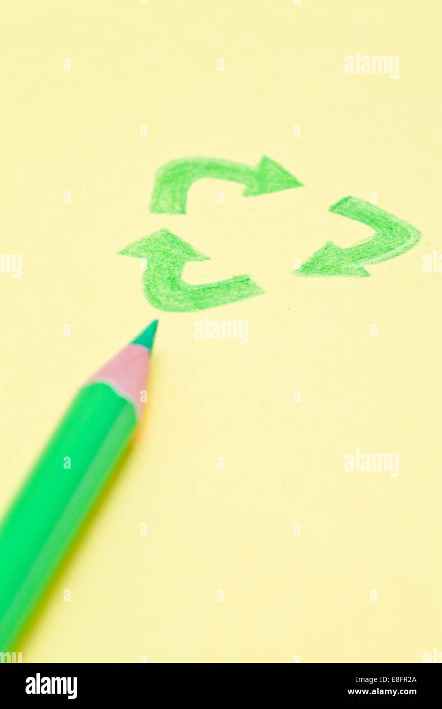 Crayon de couleur avec un dessin du symbole de recyclage sur une feuille de papier Banque D'Images