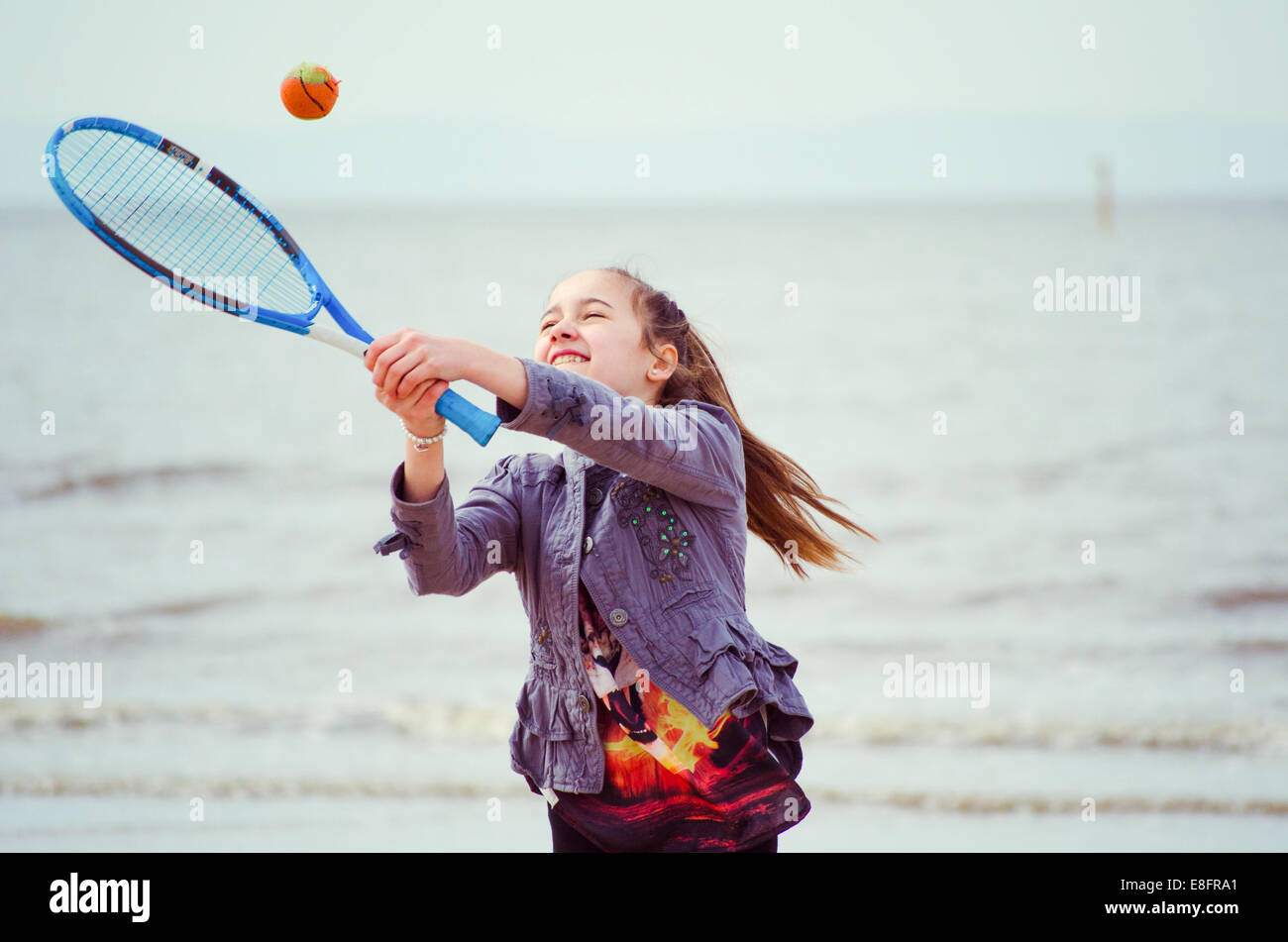 Fille jouant au tennis sur la plage Banque D'Images