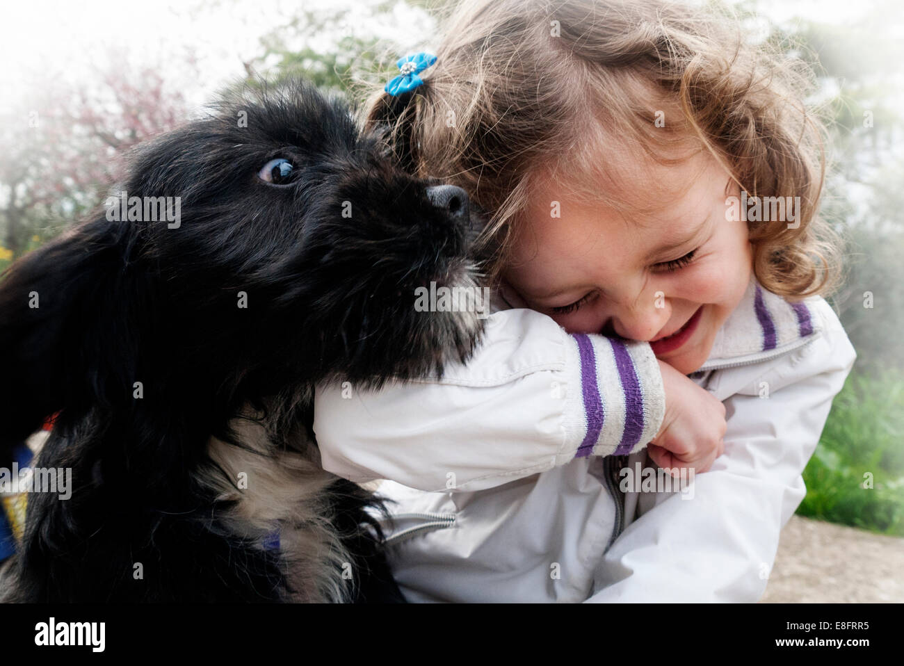 Bonne fille jouant avec un chien de chiot Banque D'Images