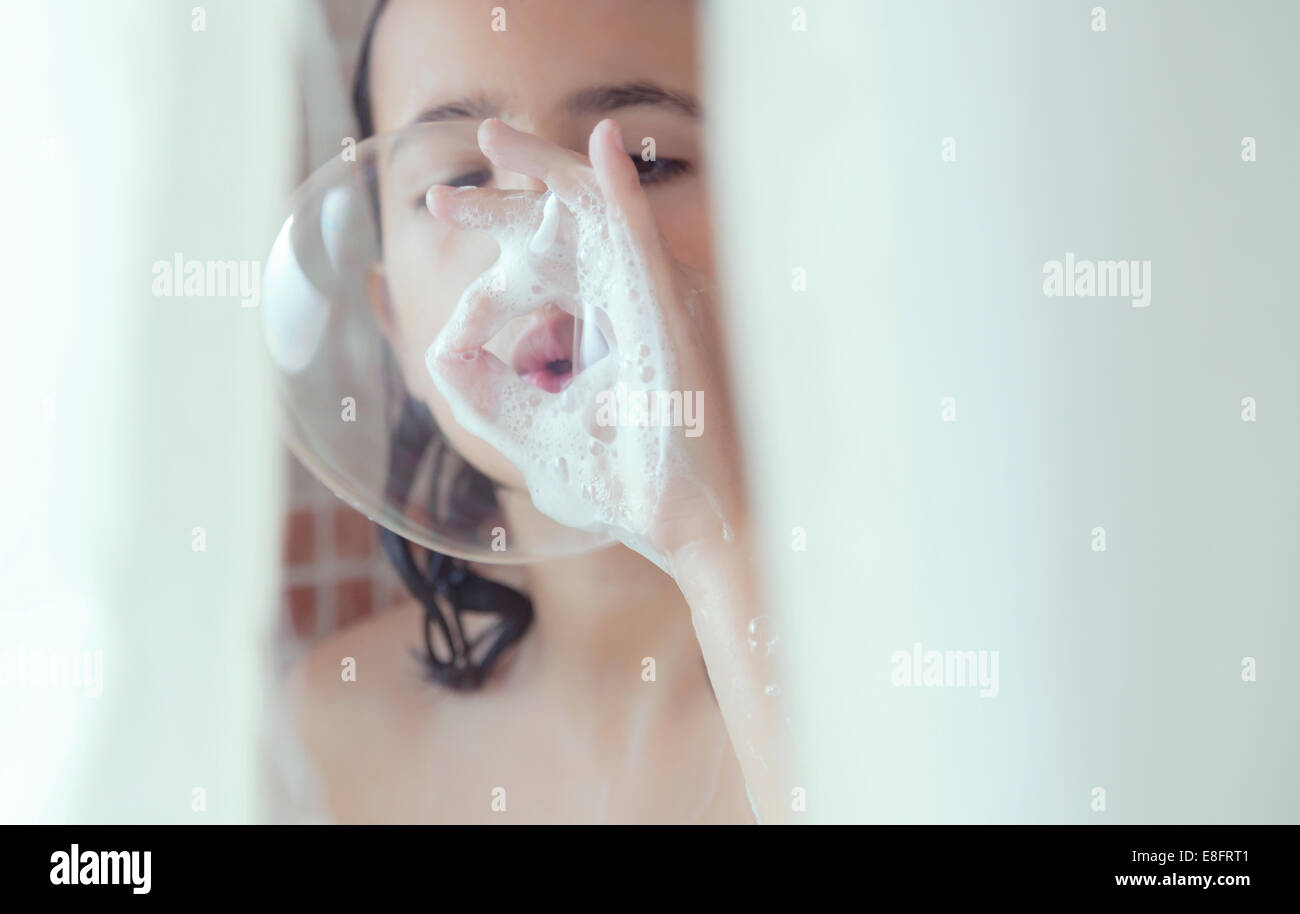 Fille debout dans la douche bulles de savon Banque D'Images