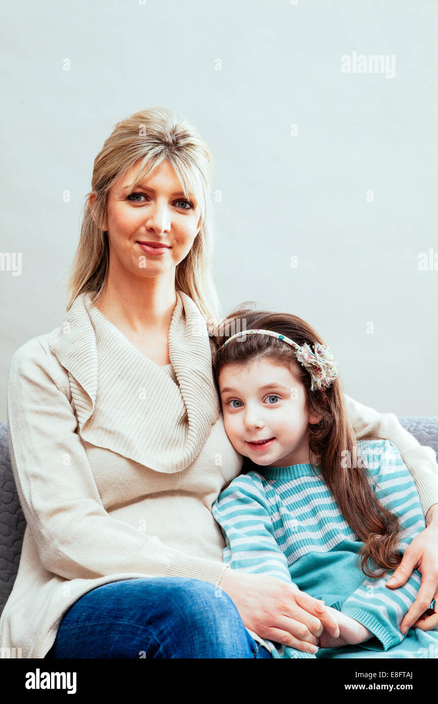 Mère et fille, assis ensemble sur le canapé Banque D'Images