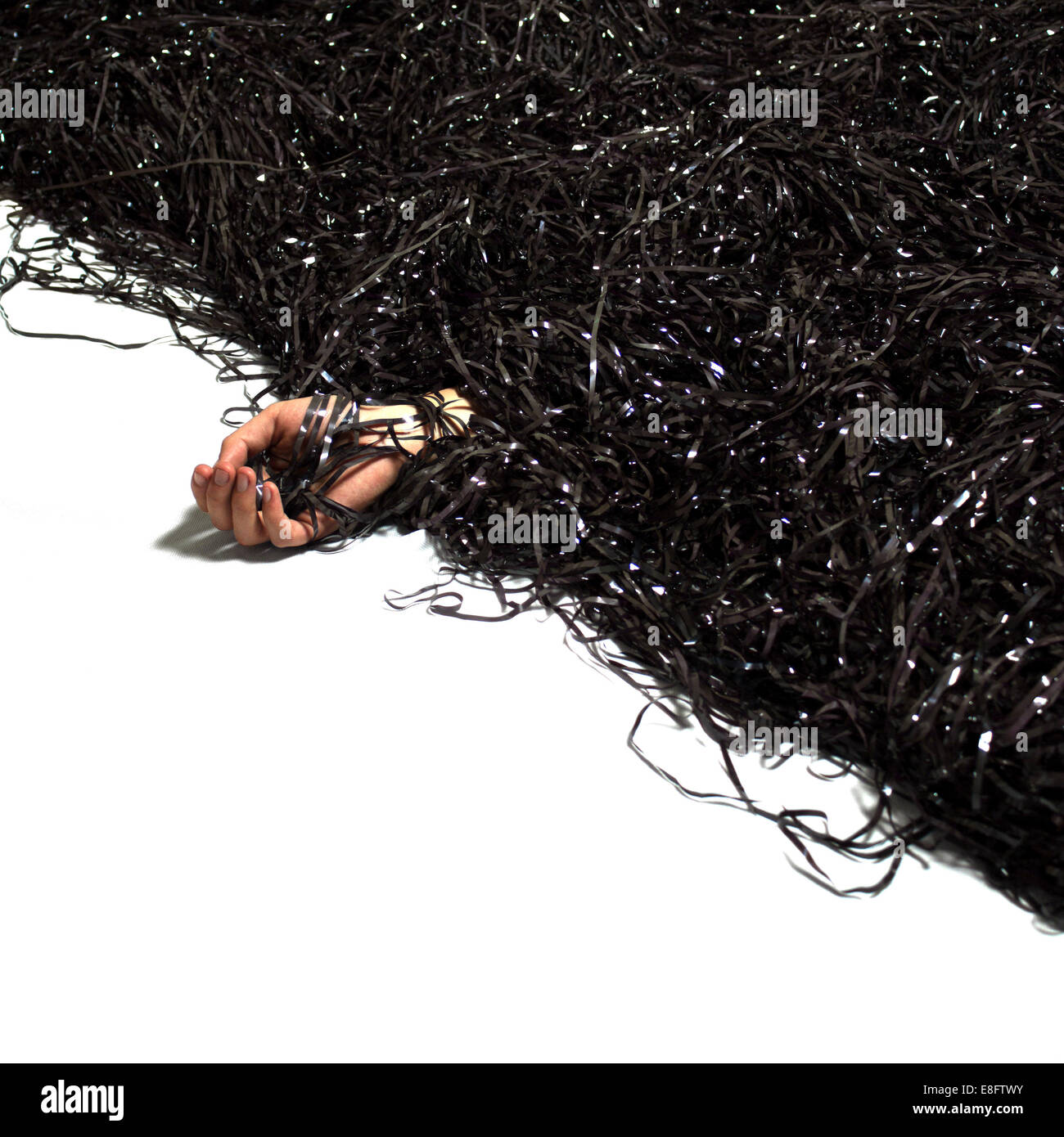 Main de l'homme émergeant de pile de bande d'enregistrement analogique Banque D'Images