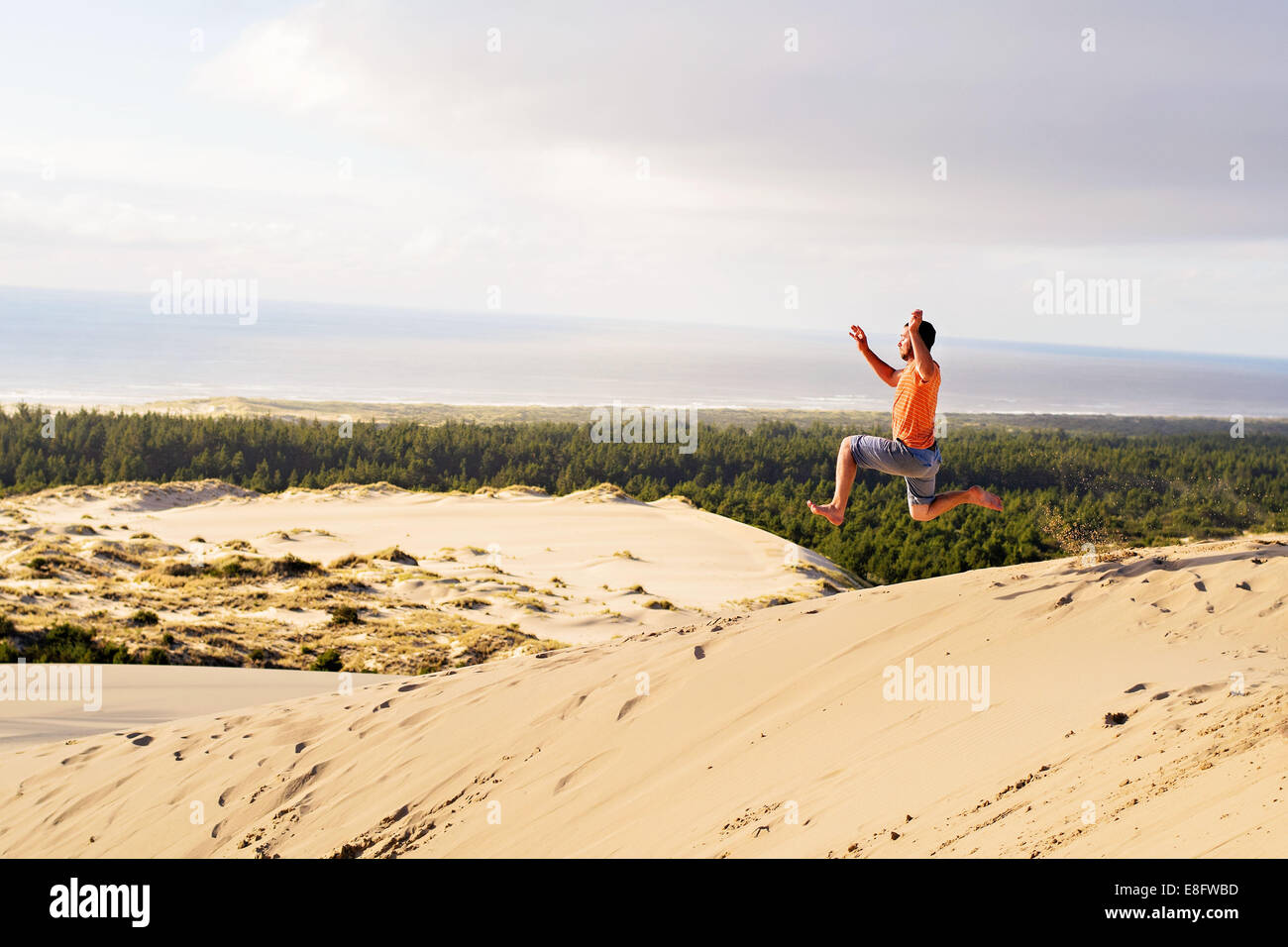 Homme courant et sautant dans les dunes de sable, Etats-Unis Banque D'Images