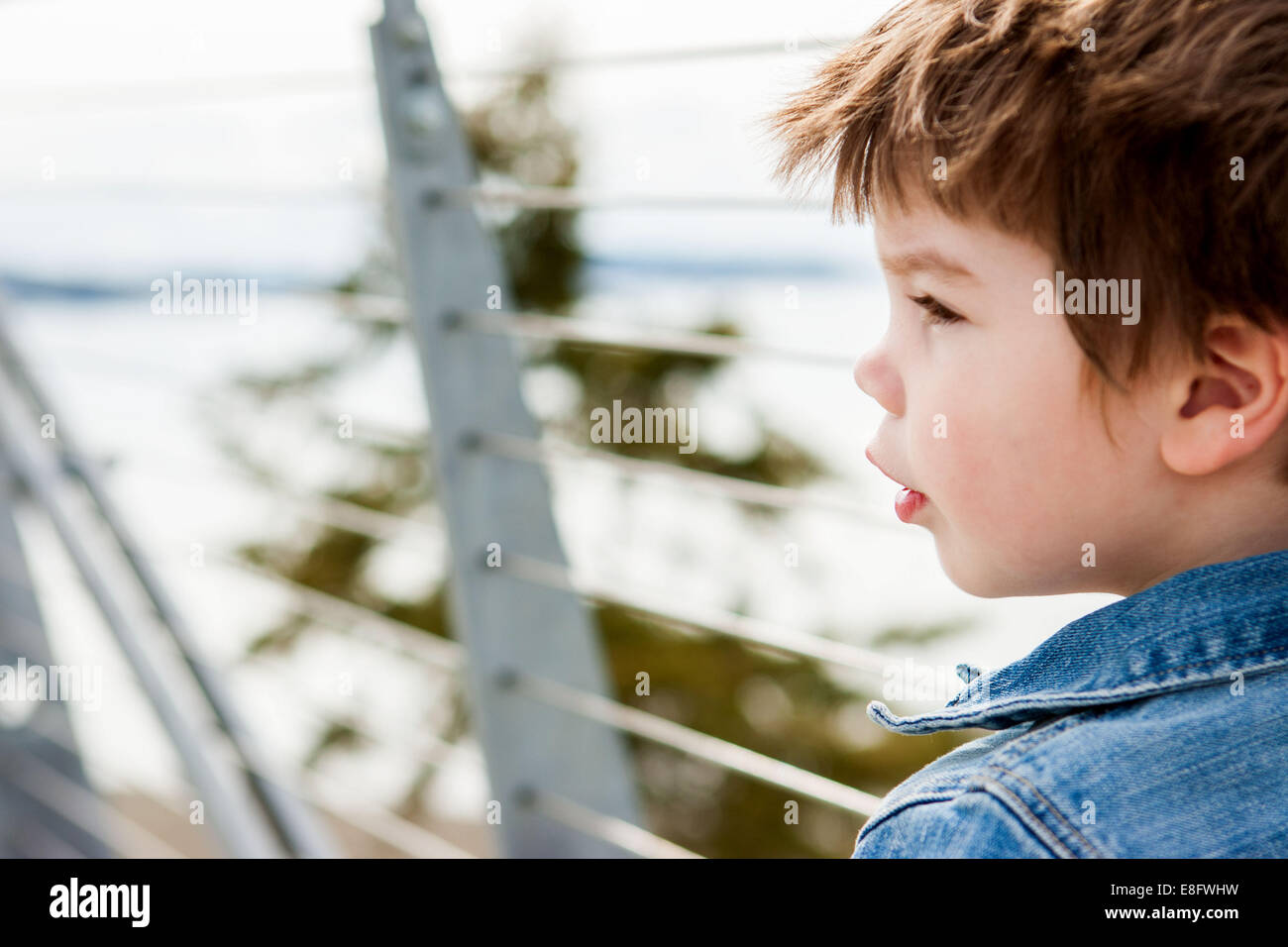 Portrait rapproché d'un garçon debout près d'une rambarde, États-Unis Banque D'Images