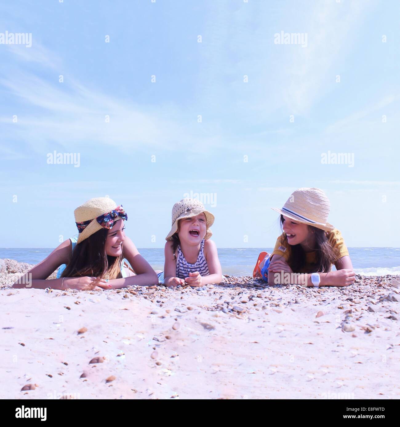 Trois jeunes filles sur la plage se trouvant sur leur face avant Banque D'Images