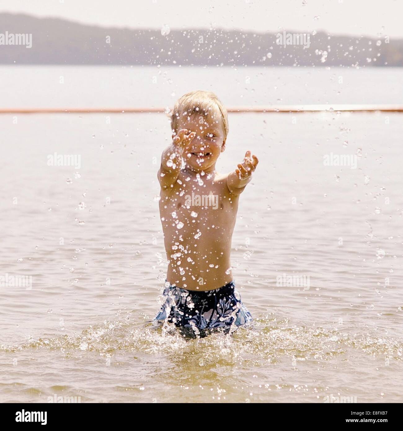 Boy splashing about dans la mer Banque D'Images