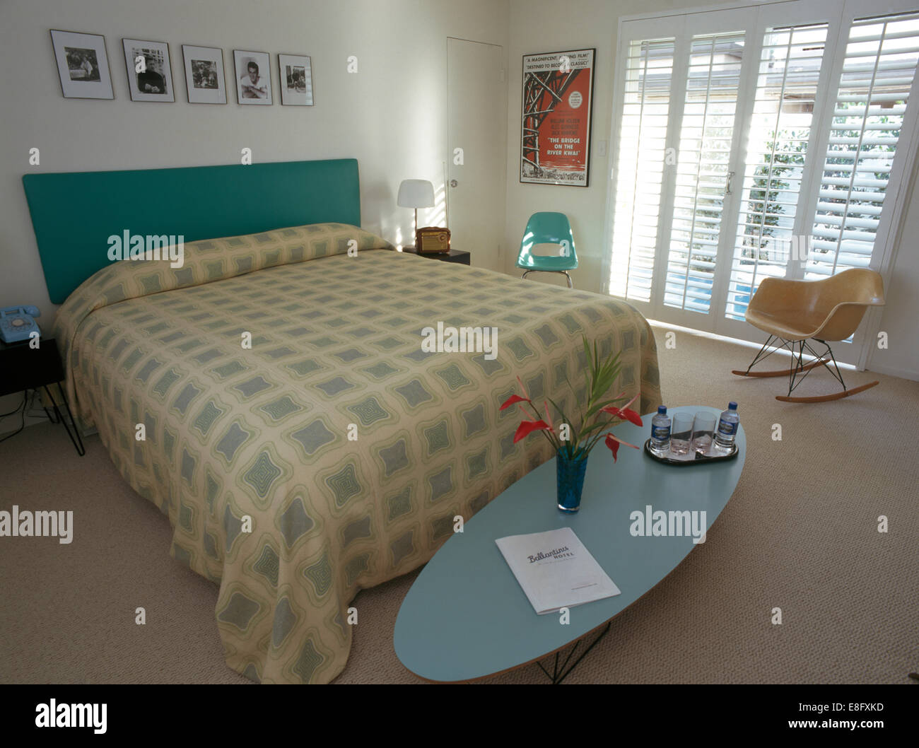 Table basse ovale et Charles Eames chaise dans une chambre moderne et agrémentées de couvercle sur le lit avec tête de lit rembourrée Banque D'Images