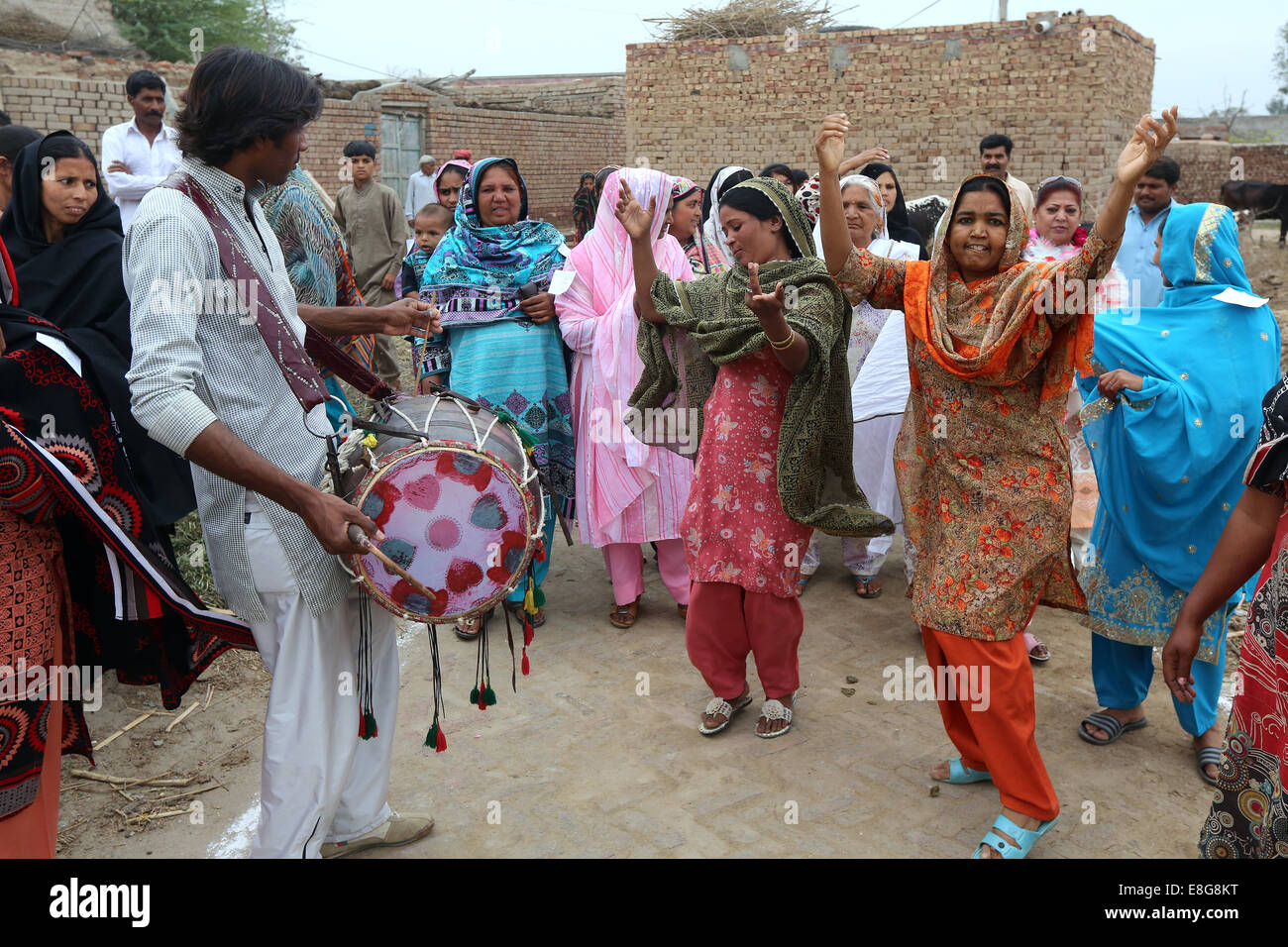 Les femmes habillés traditionnels colorés dansant dans un village près de Faisalabad, Pakistan Banque D'Images