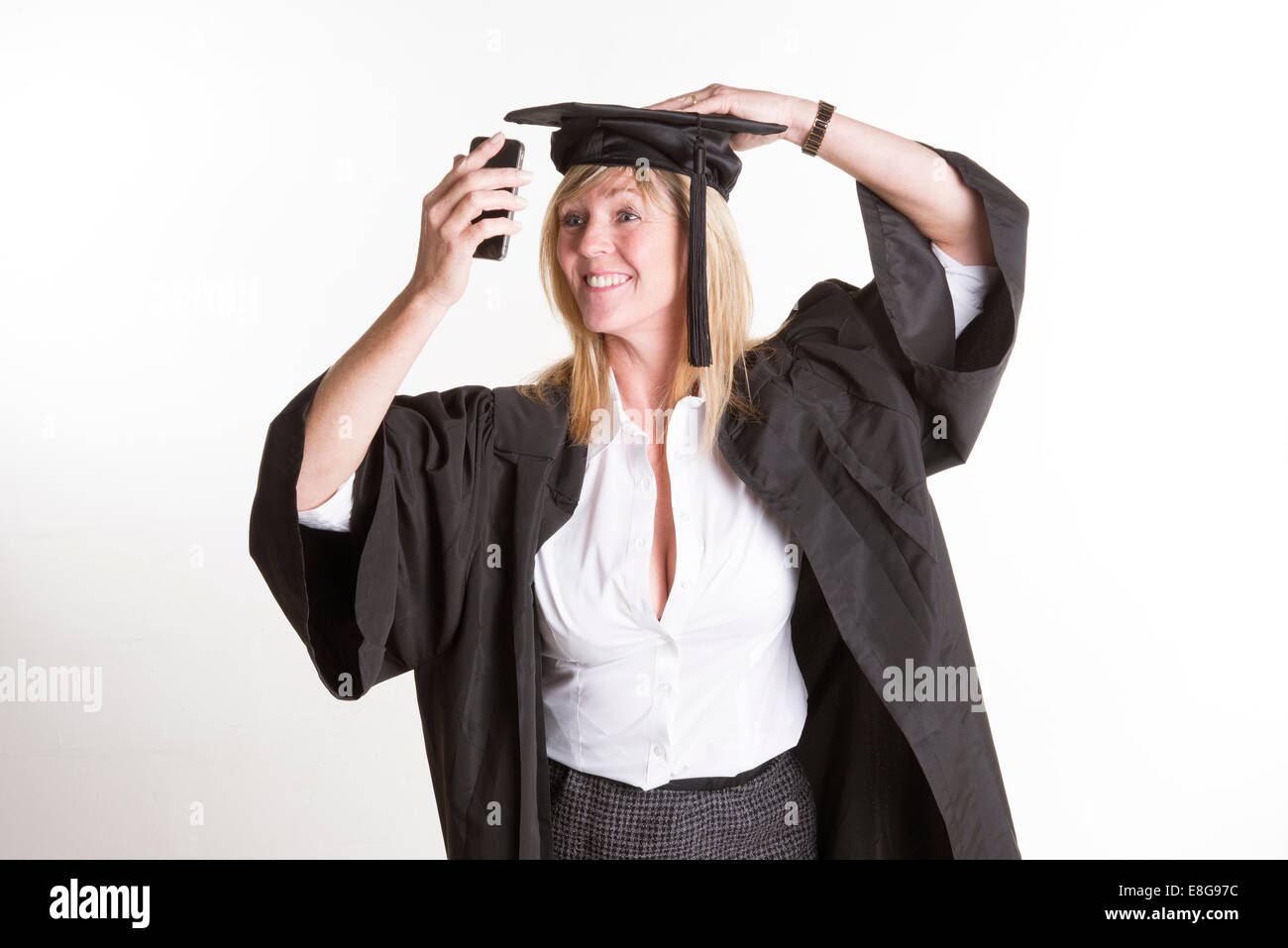 Mature student in cap and gown prenant une photo selfies Banque D'Images