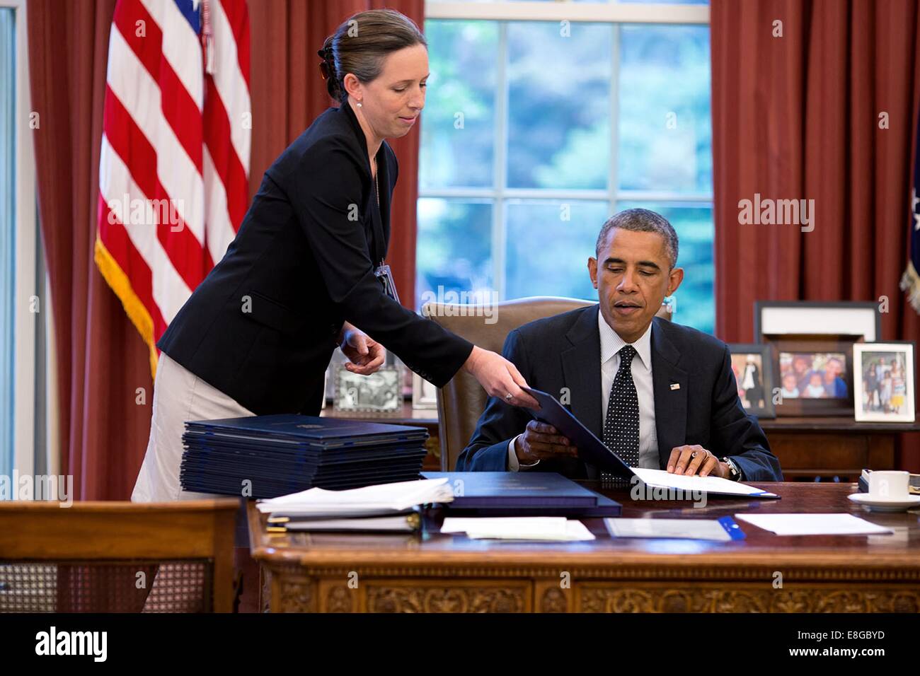 Le président américain Barack Obama, de l'aide du personnel Secrétaire Joani Walsh, signes d'une variété de projets dans le bureau ovale de la Maison Blanche le 8 août 2014 à Washington, DC. Banque D'Images