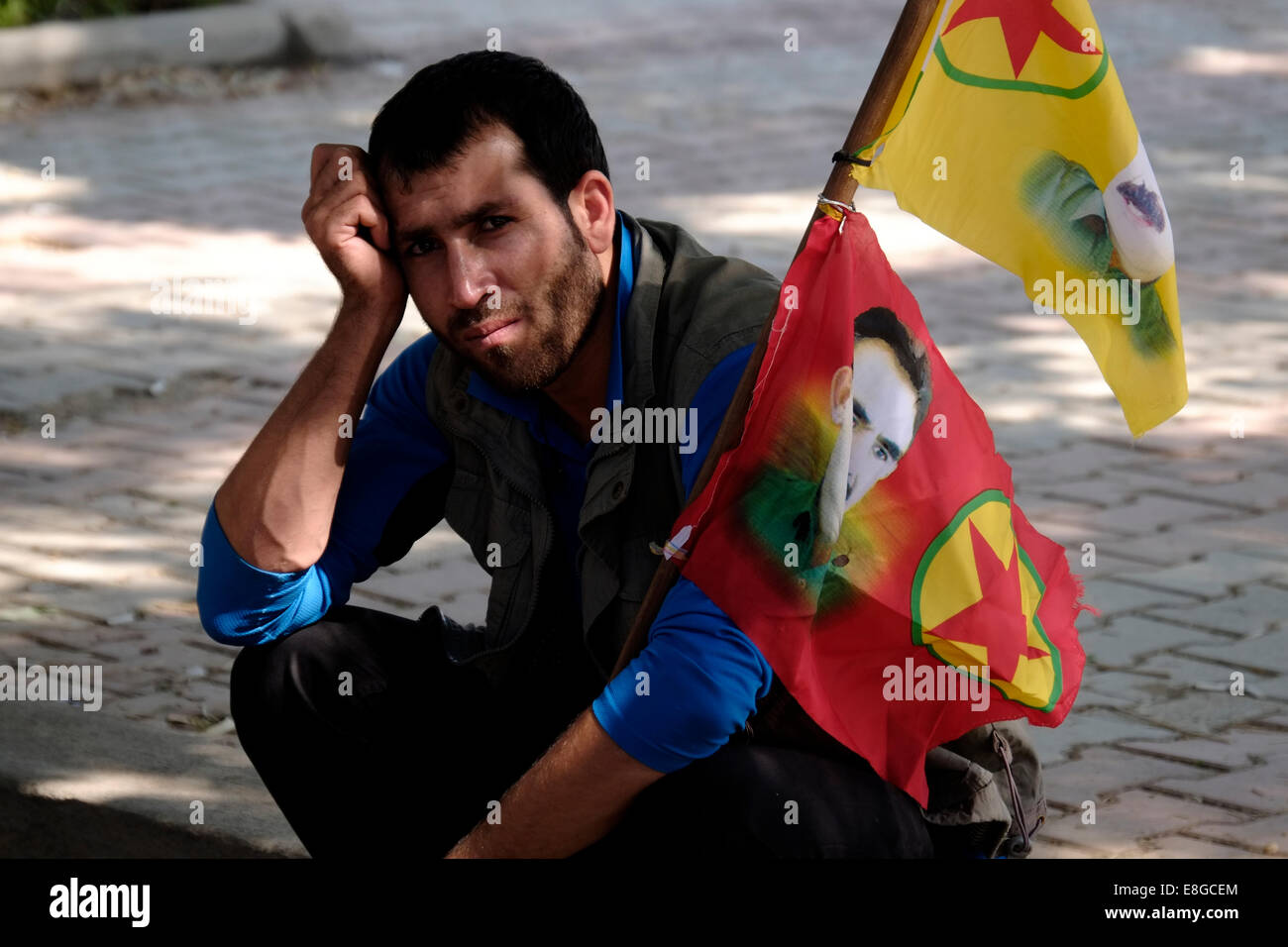 Un homme kurde avec les drapeaux portant la figure d'Abdullah Ocalan, membre fondateur de l'organisation militante du Parti des Travailleurs du Kurdistan (PKK) au cours d'une protestation Kudish à l'appui de Kurdes syriens souffrant d'ISIS les attaques dans la ville syrienne de Kobane.dans la ville kurde d'Erbil dans le Nord de l'Irak Banque D'Images