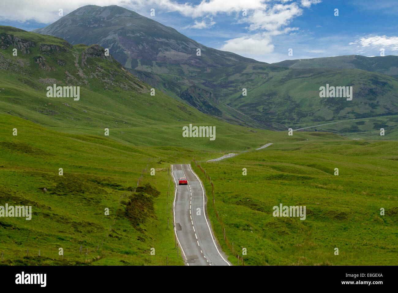 Vaste paysage spectaculaire et route étroite serpentant à travers les collines verdoyantes et les montagnes du Parc National de Cairngorms, en Écosse Banque D'Images