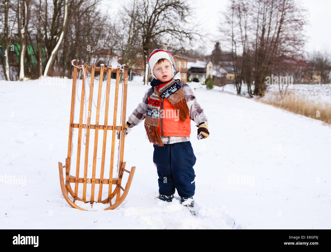 Garçon enfant sur un traîneau dans la neige Banque D'Images