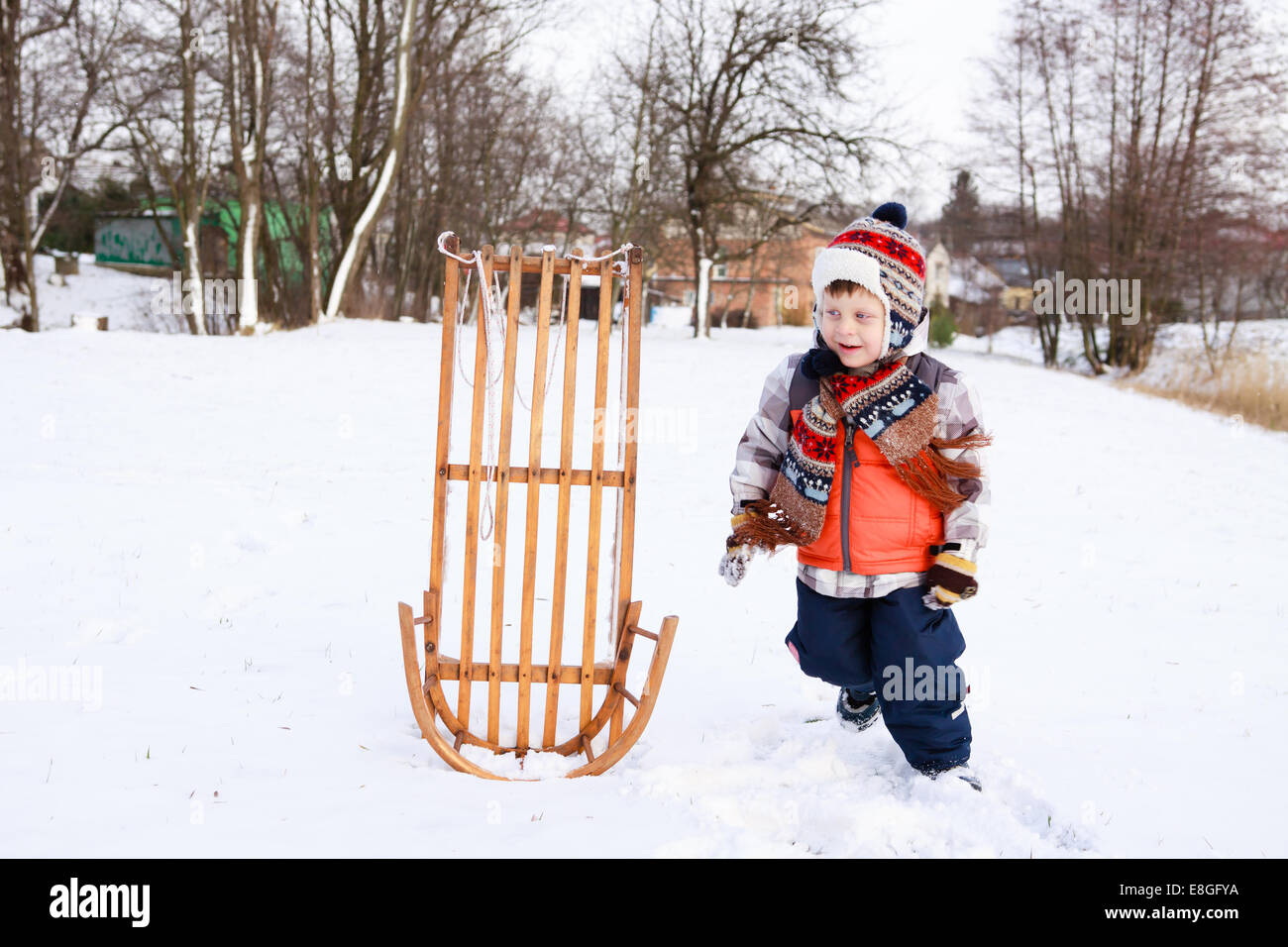 Garçon enfant sur un traîneau dans la neige Banque D'Images