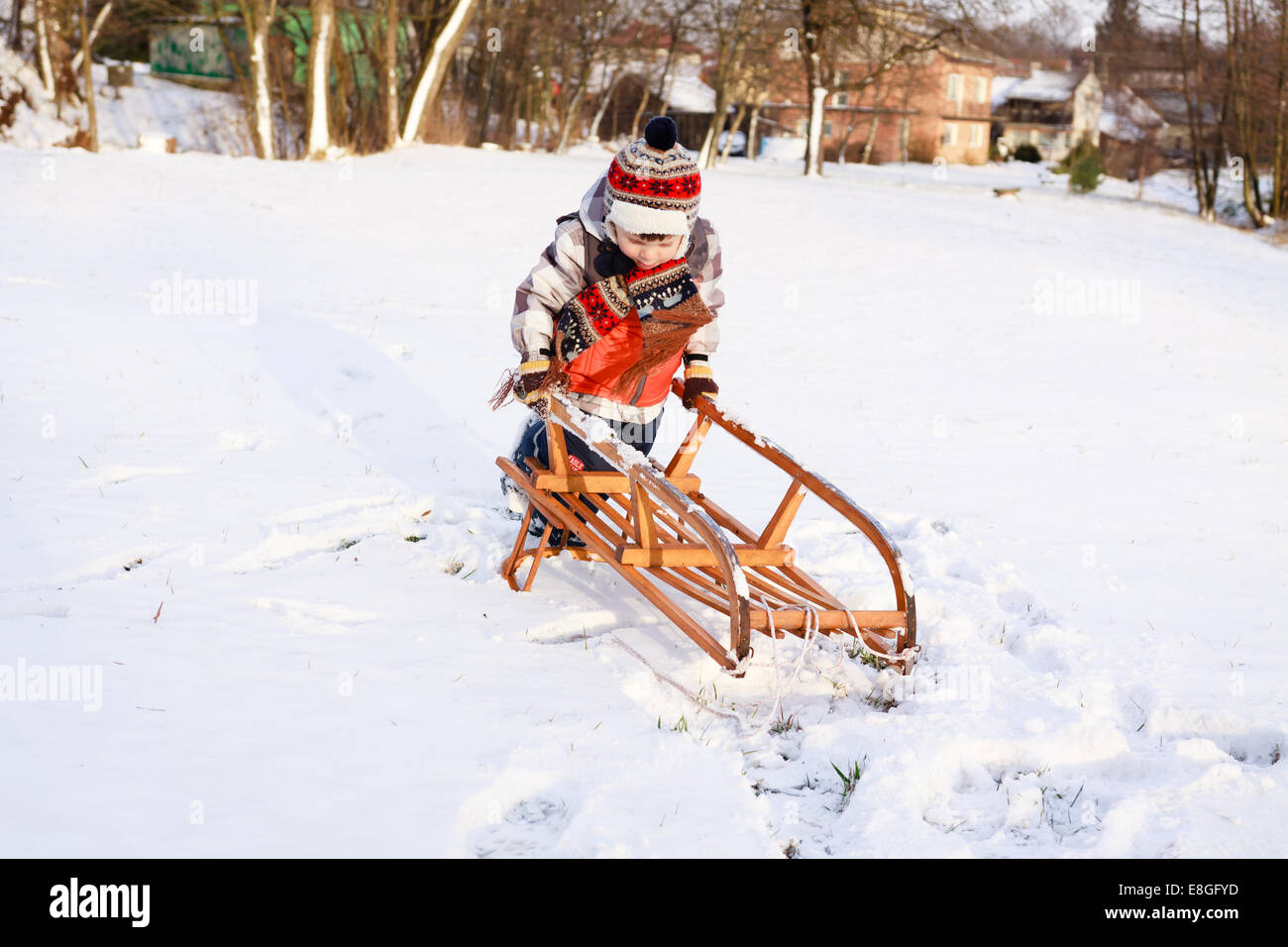 Garçon enfant sur un traîneau dans la neige Banque D'Images
