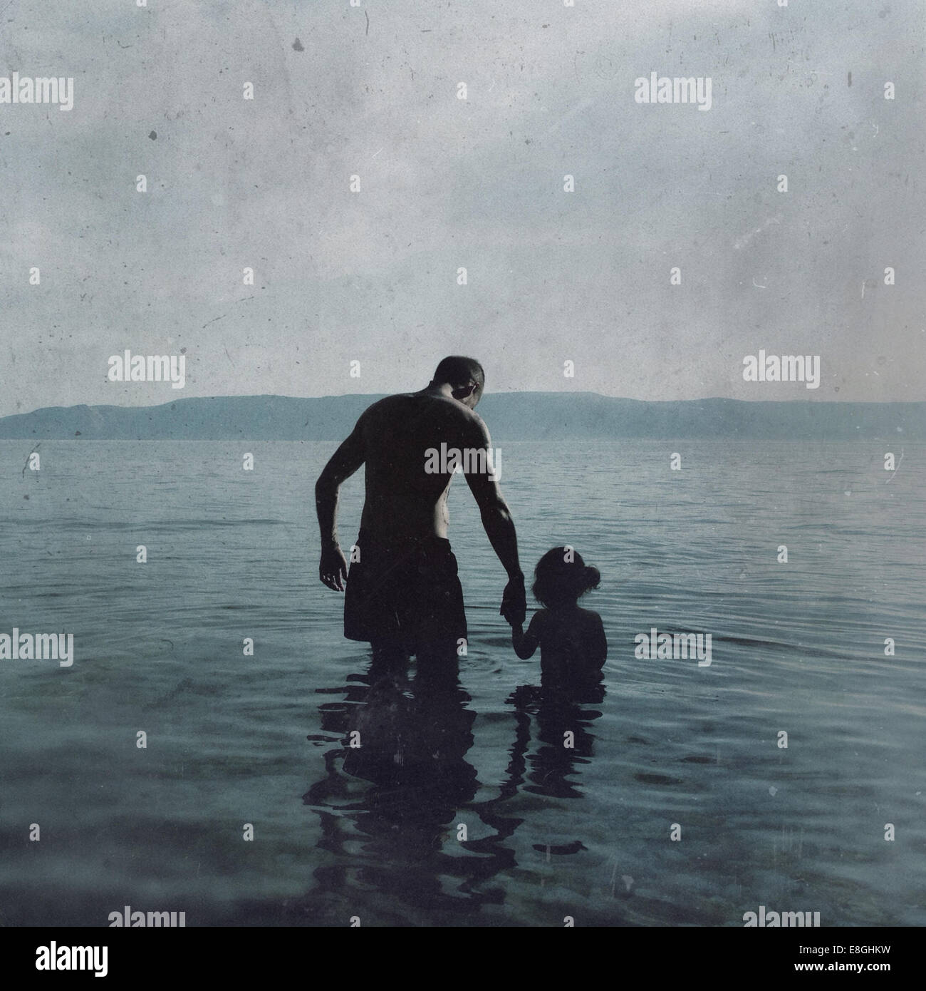 Vue arrière d'un Père et d'une fille qui marchent dans la mer, Croatie Banque D'Images