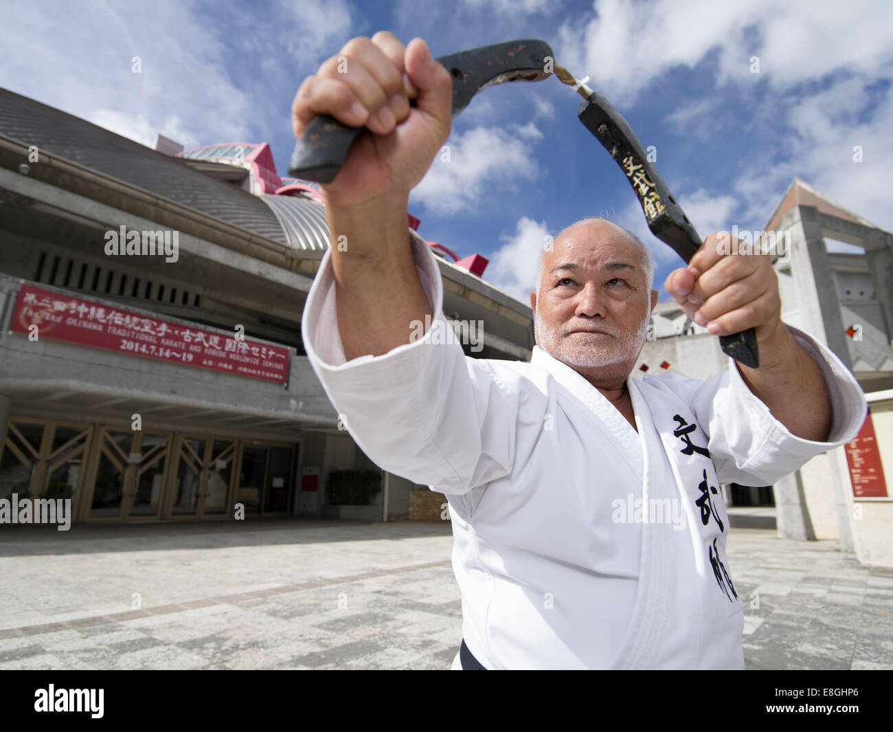 Masahiro Nakamoto - 10ème Dan Hanshi, Okinawa Kobudo Dentou avec nunchaku en dehors du Budokan, de la ville de Naha, Okinawa Banque D'Images