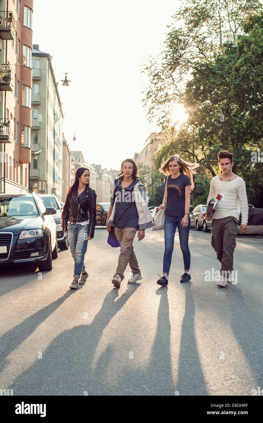 Toute la longueur de certains élèves du secondaire walking on city street Banque D'Images