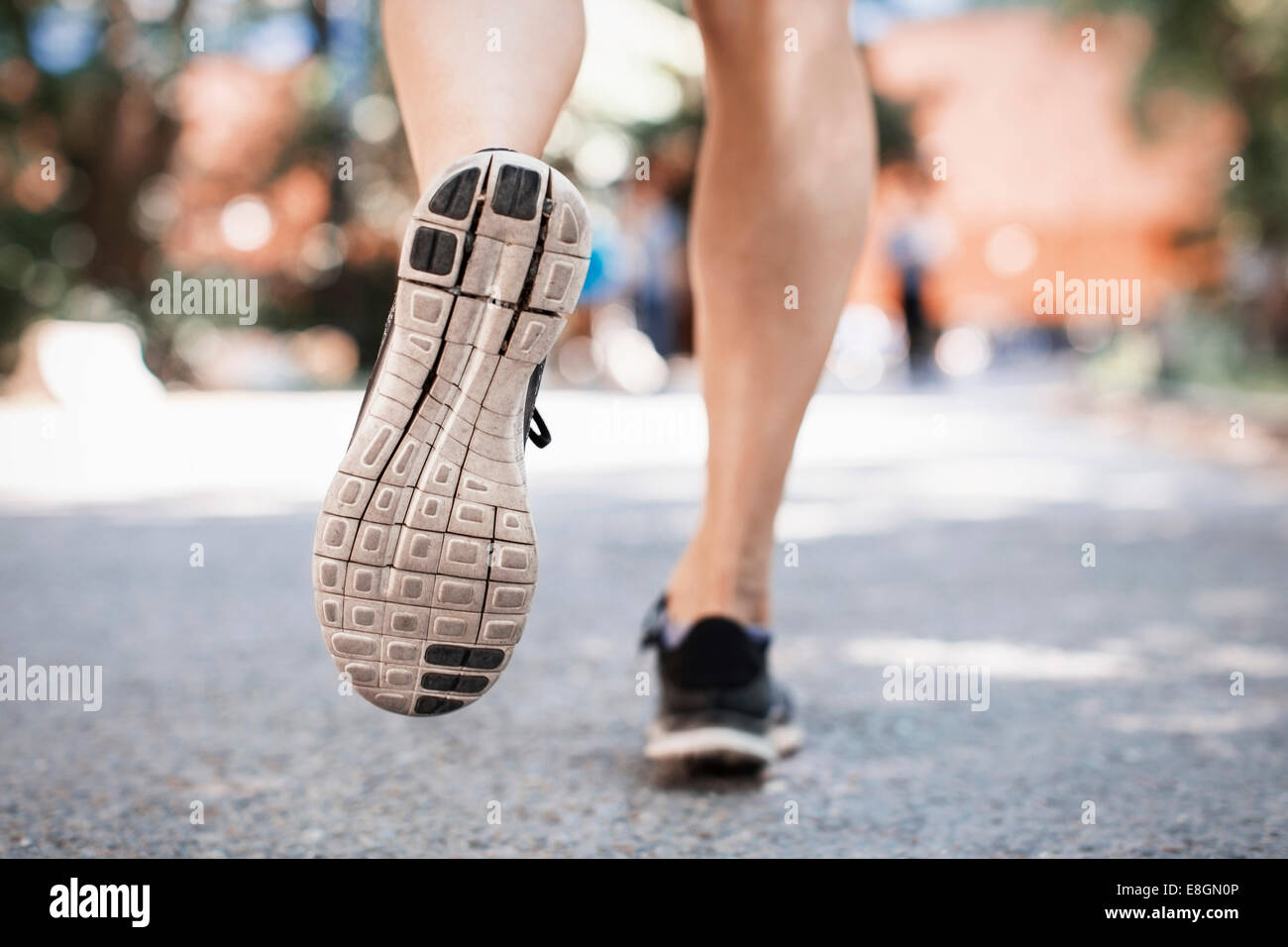 La section basse de la femme dans les chaussures de sport courir sur la rue Park Banque D'Images