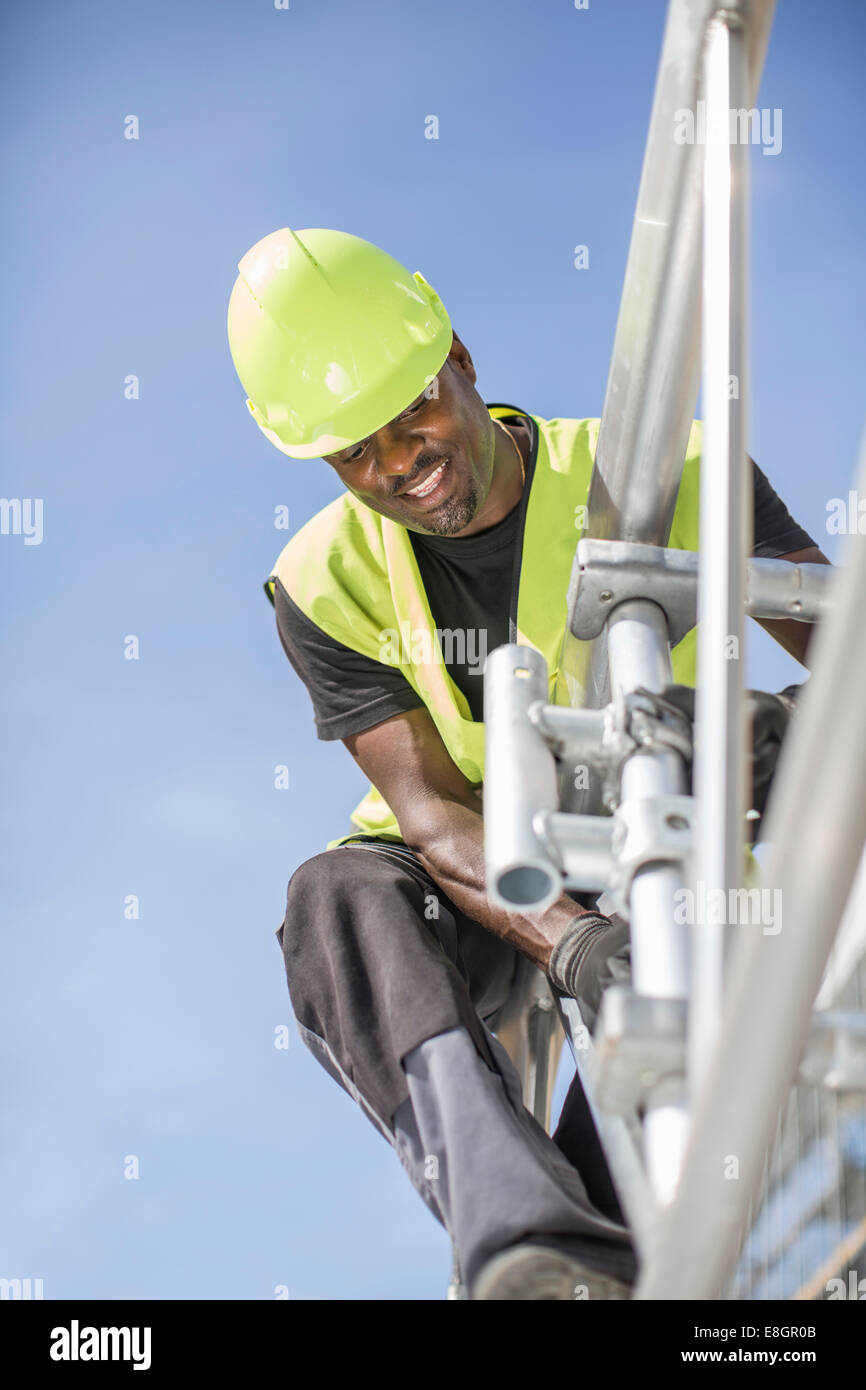 Low angle view of workers working on construction frame contre ciel clair Banque D'Images