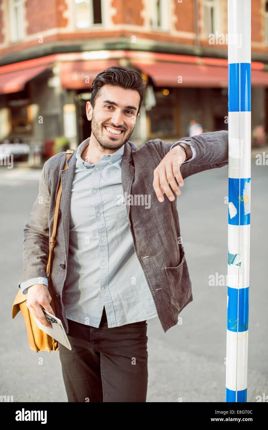 Portrait of happy businessman standing on city street Banque D'Images