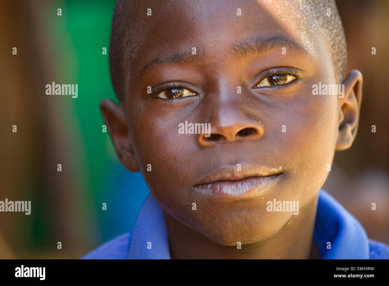 Un jeune garçon d'un village zambien se penche sur l'appareil photo. Banque D'Images