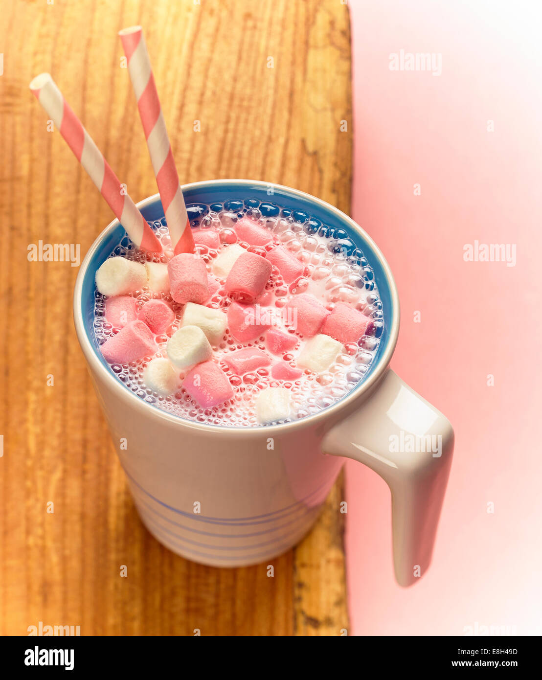 Une tasse de lait fouetté aux fraises avec mini guimauves et pailles Banque D'Images