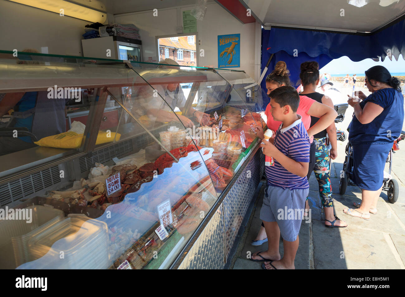 Young boy holding ice cream choisir du poisson frais à partir d'un décrochage. Banque D'Images