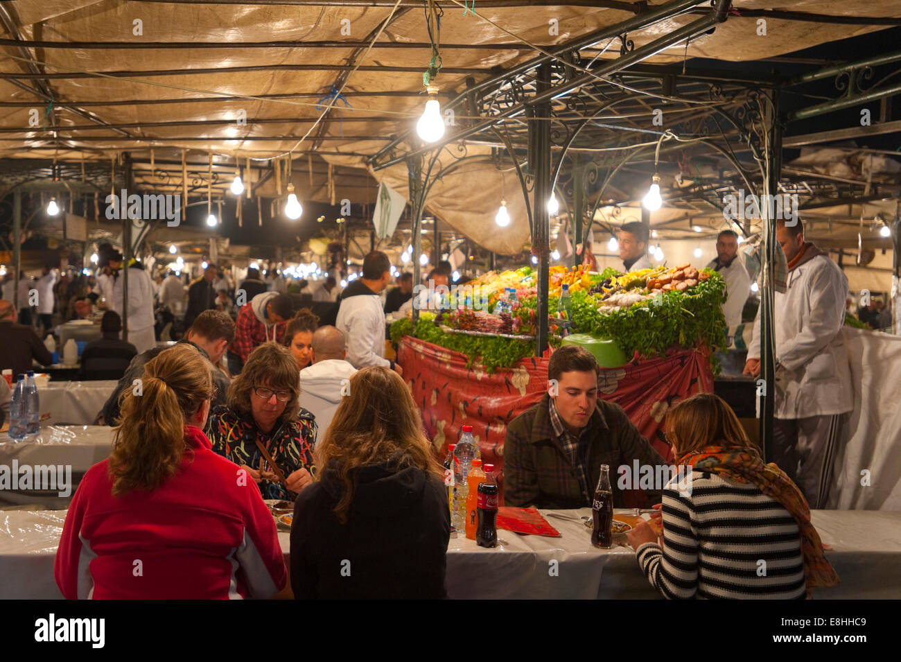 Vue horizontale de touristes de manger des aliments sur les étals de la Place Jemaa el Fna (Place Djemaa el Fna à Marrakech la nuit. Banque D'Images