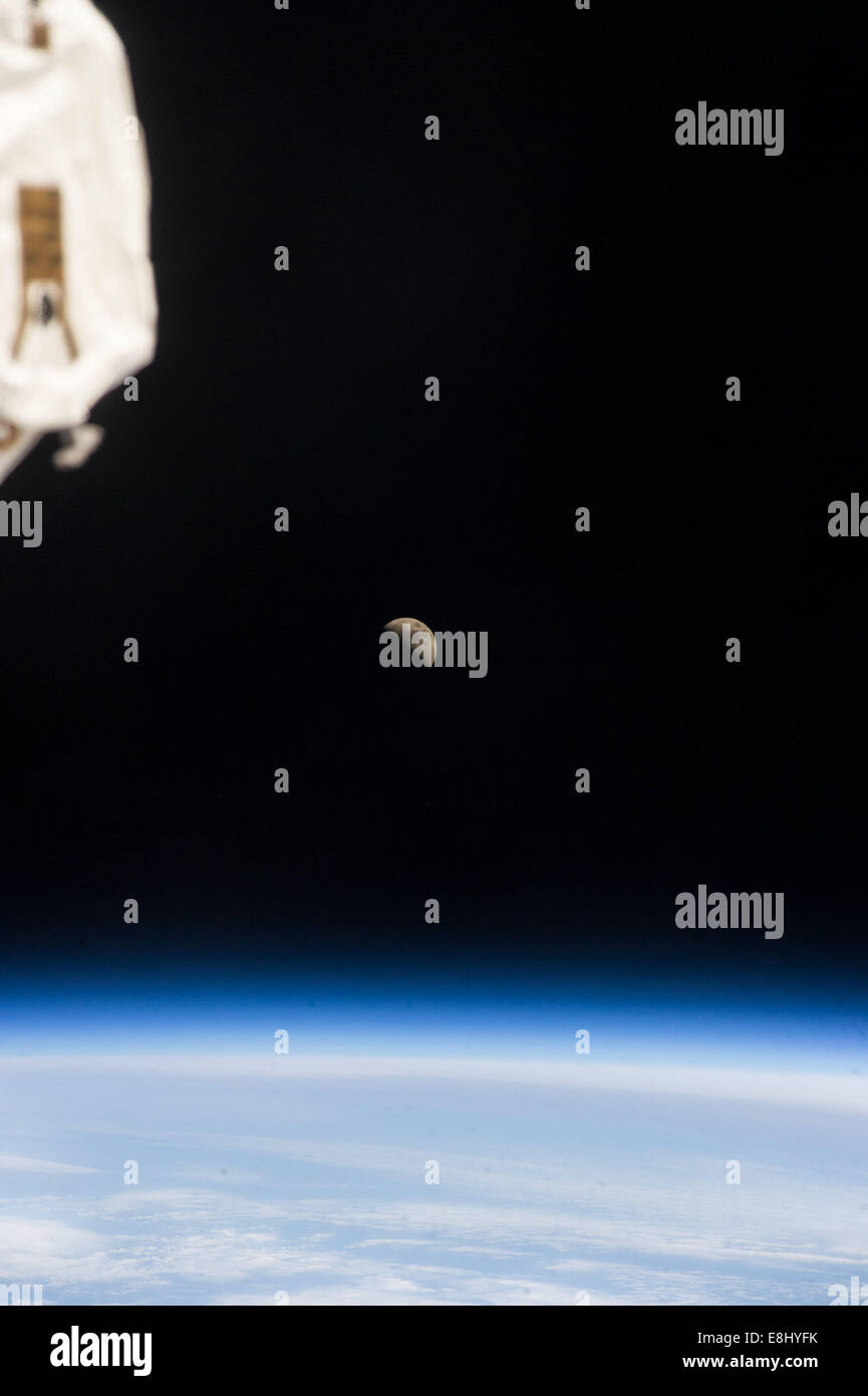 La Lune est vue clairement au-dessus de la Terre, capturant sa position céleste dans le ciel. La Lune reste le seul satellite naturel de la Terre et joue un rôle crucial dans divers phénomènes naturels tels que les marées. Banque D'Images