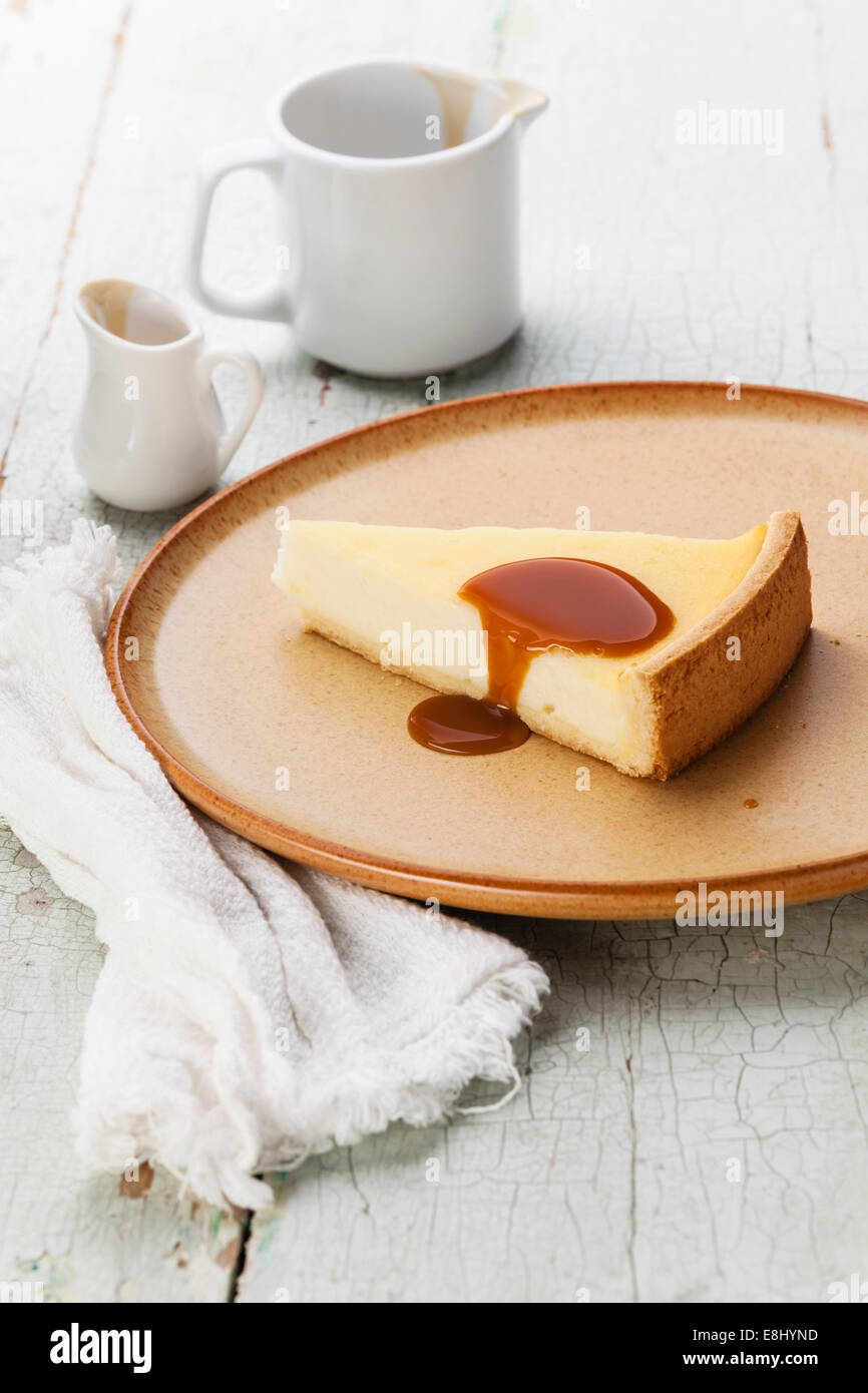 Gâteau au fromage classique sauce caramel et sur la plaque sur bleu texture background Banque D'Images