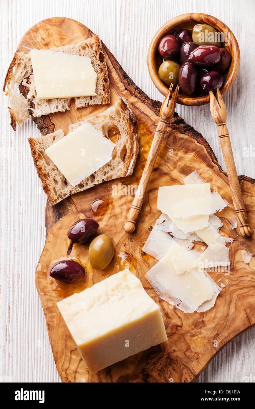 Des sandwichs de fromage Parmesan et olives sur une planche à découper en bois d'olivier Banque D'Images