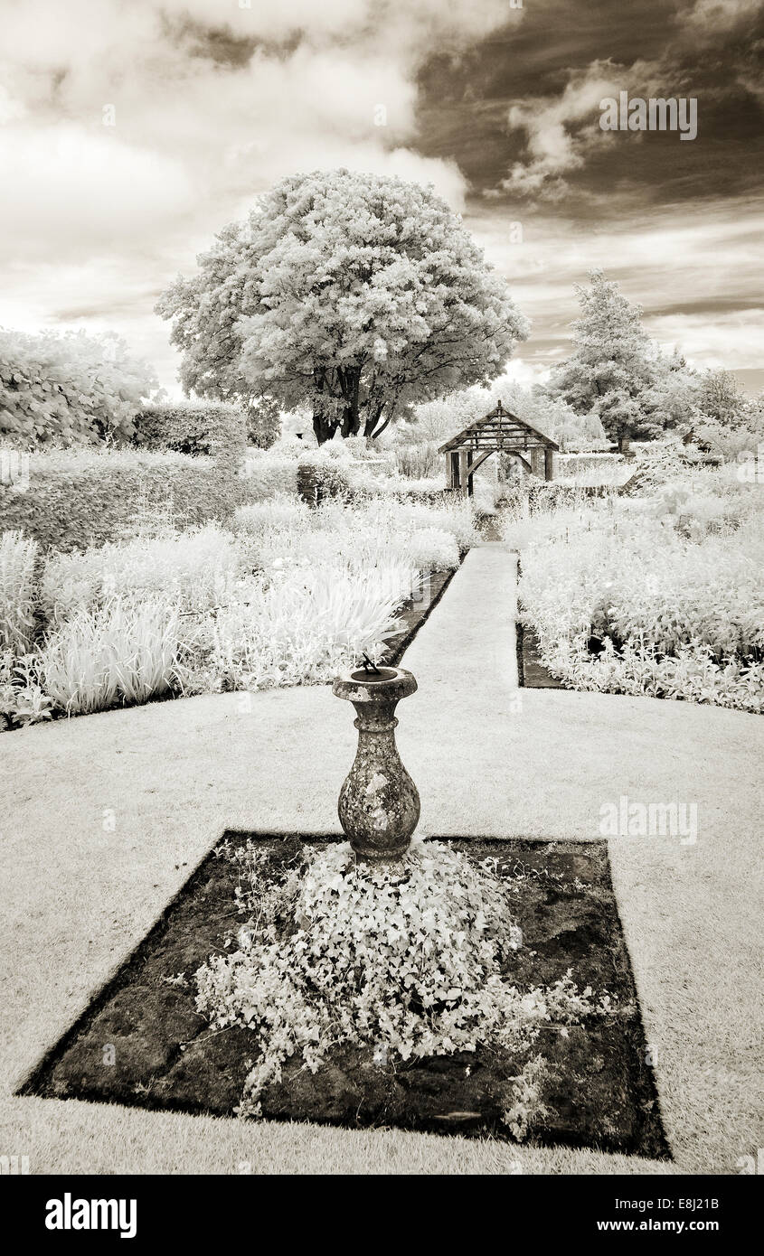 Photographie infrarouge d'un jardin anglais classique cadran solaire orné fonction sur pelouse avec des frontières de plantes vivaces à Wollerto Banque D'Images