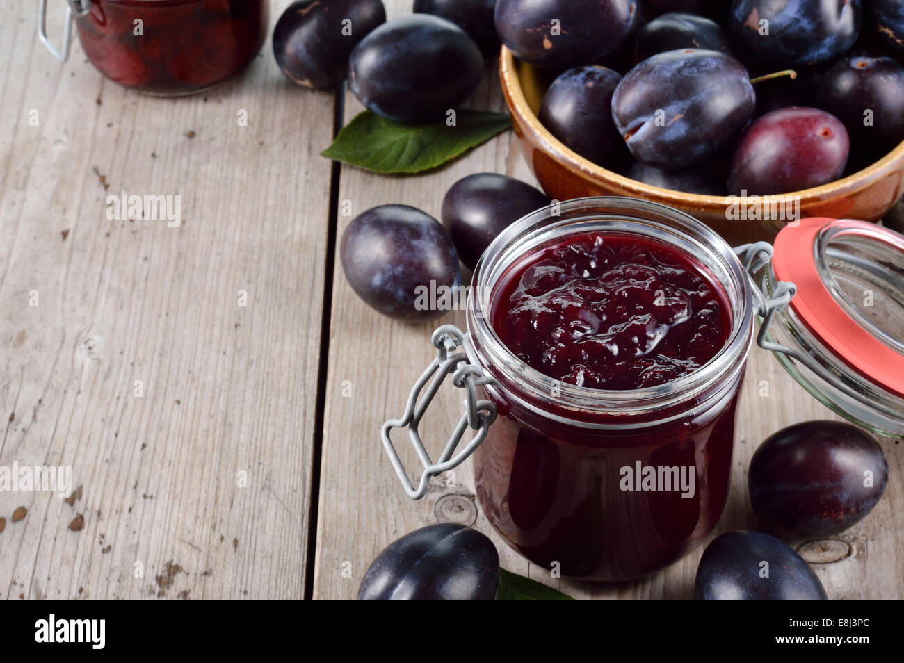 Confiture de prune maison et de groupe de prunes sur la vieille table en bois. Beaucoup de copyspace. Banque D'Images
