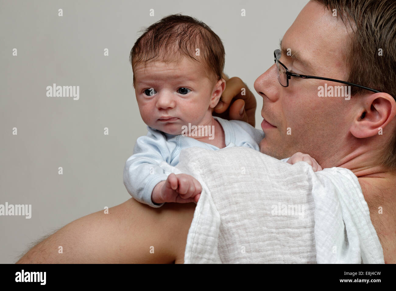 Trois semaines bébé garçon sur son épaule par son père, avec un chiffon burp Banque D'Images