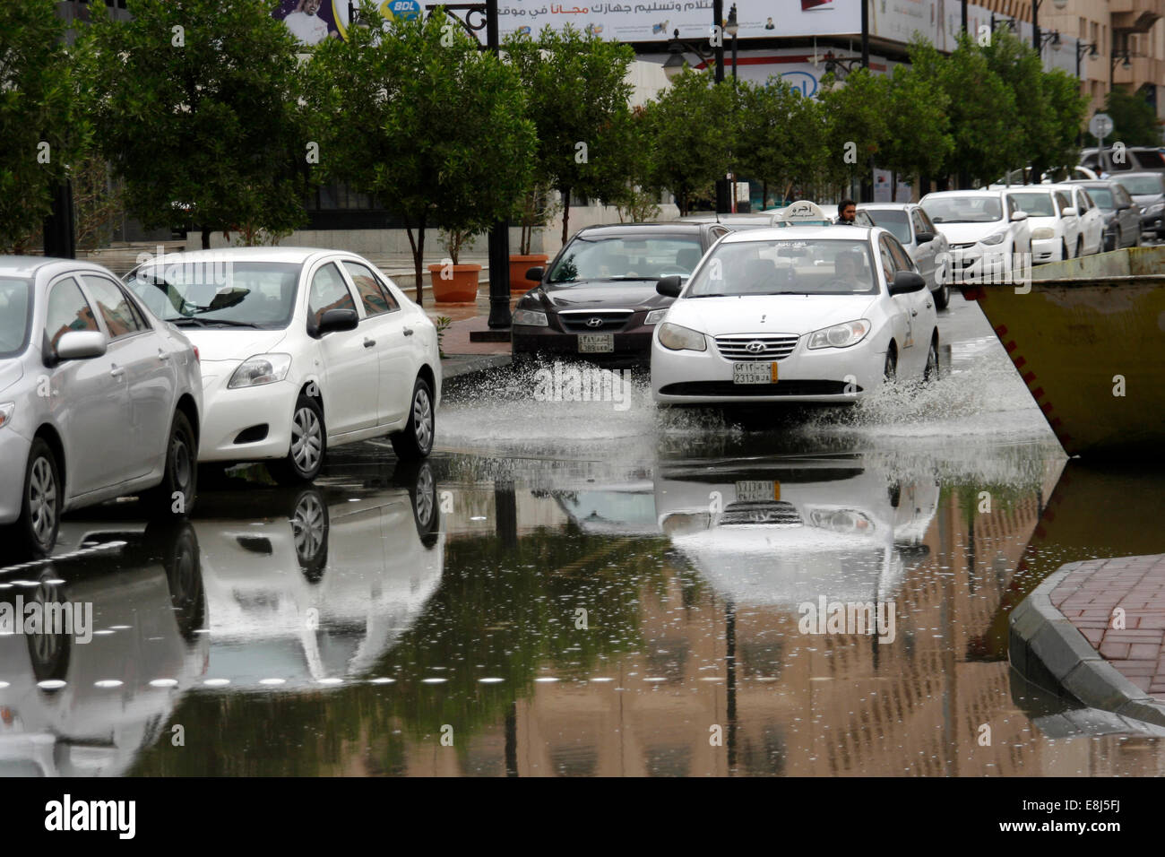 Un taxi conduit par l'agglomération de l'eau de pluie dans les rues de Riyadh, Arabie Saoudite Banque D'Images