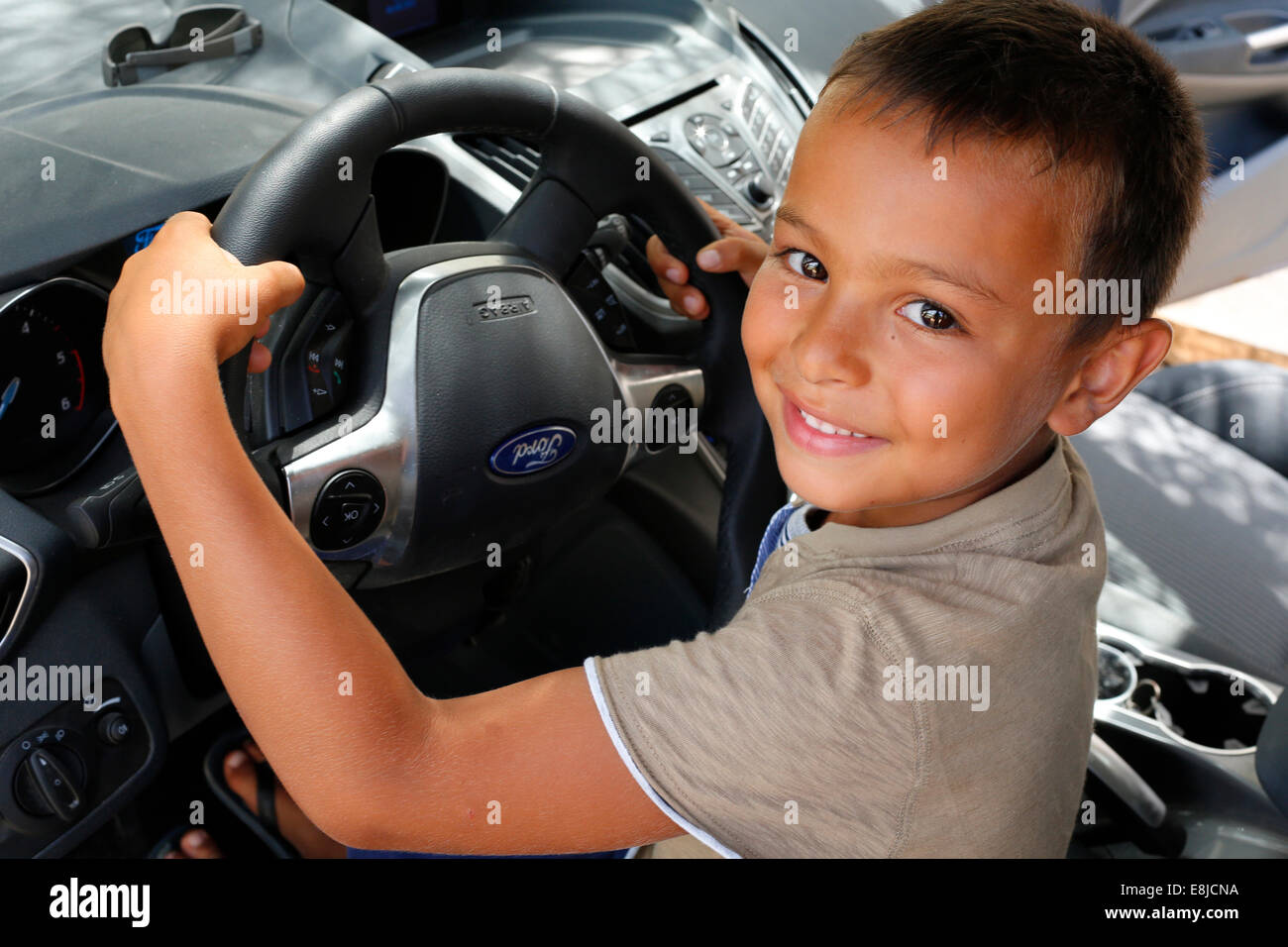Garçon de 6 ans fait semblant de conduire une voiture Banque D'Images