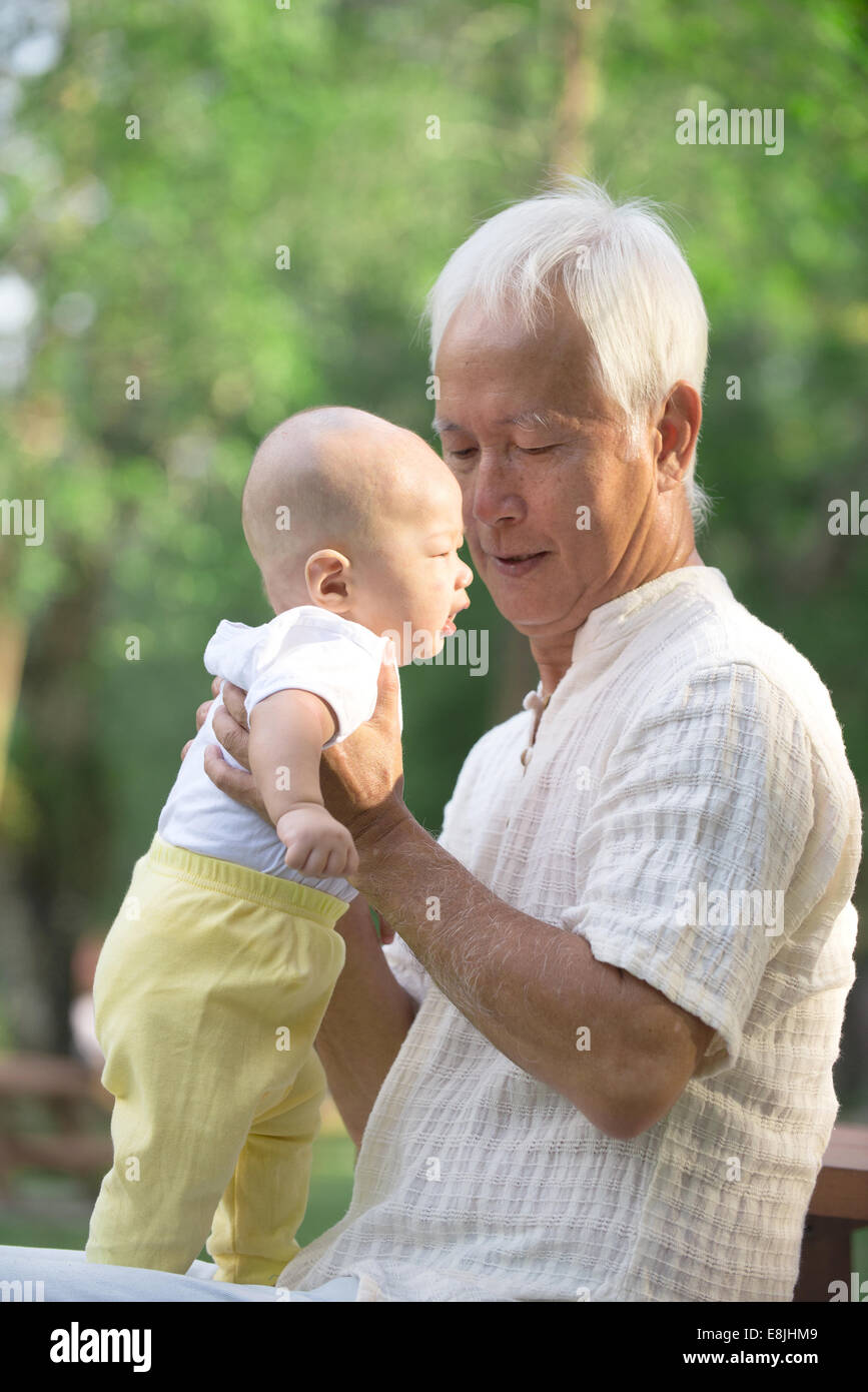 Grand-parent asiatique chinois s'amusant avec son petit-fils piscine Banque D'Images