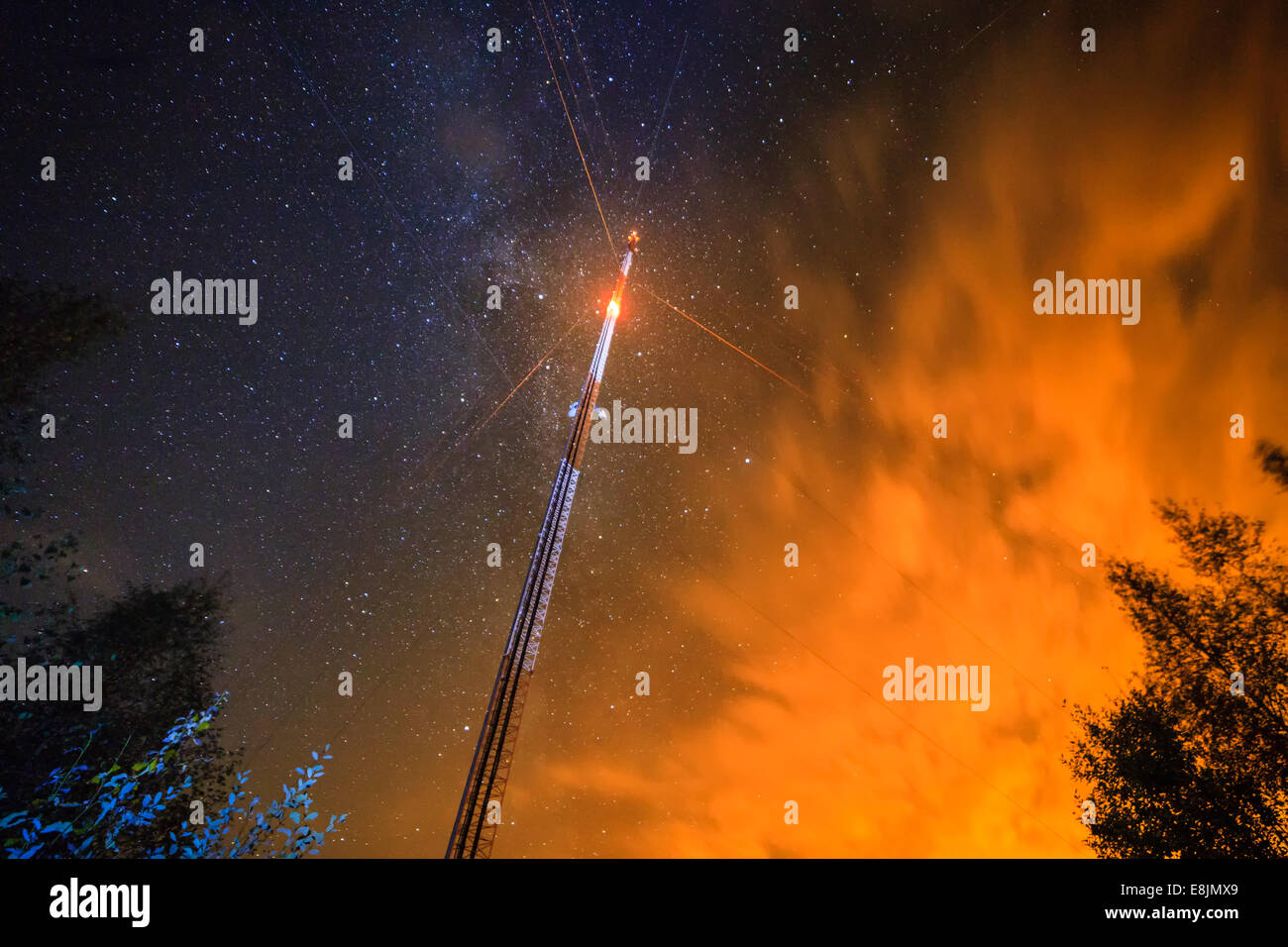 Une tour de télécommunications avec une lumière clignotante. Ciel de nuit avec des étoiles sur le fond. Banque D'Images