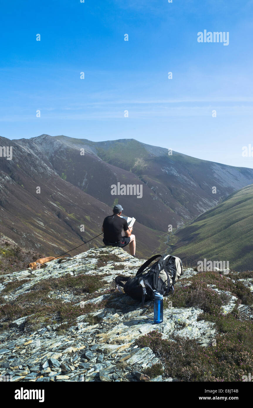 dh Rambler avec carte GASGALE GILL LAKE DISTRICT Hiker dog pays Walker royaume-uni randonnée en montagne cumbria marche personnes vue sur la campagne Banque D'Images