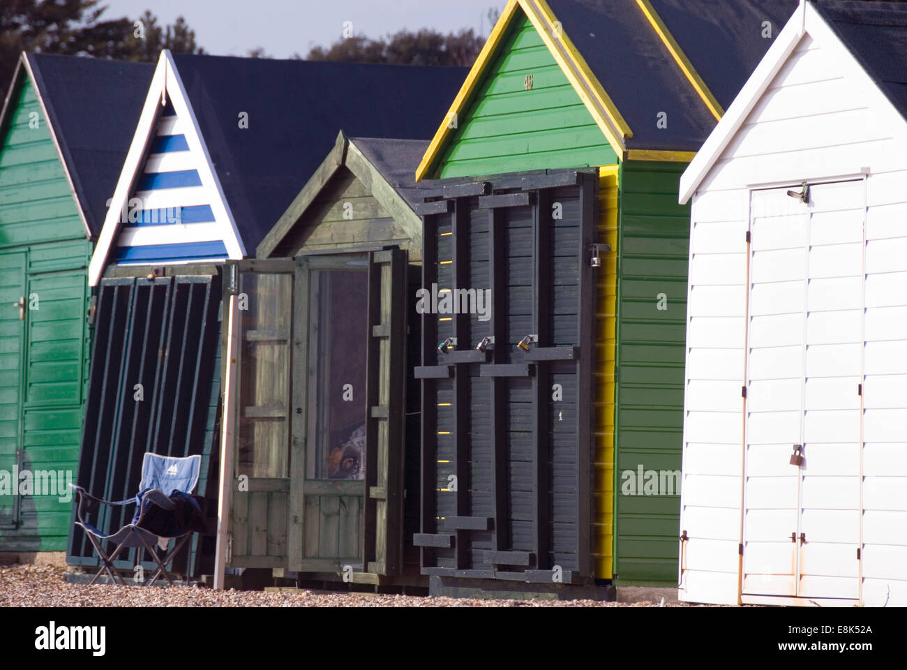 Lee sur le Solent, Hampshire, Royaume-Uni 02 Avril 2013 : vacant Président est assis devant une rangée de cabines de plage vert doux sur un jour de printemps ensoleillé Banque D'Images