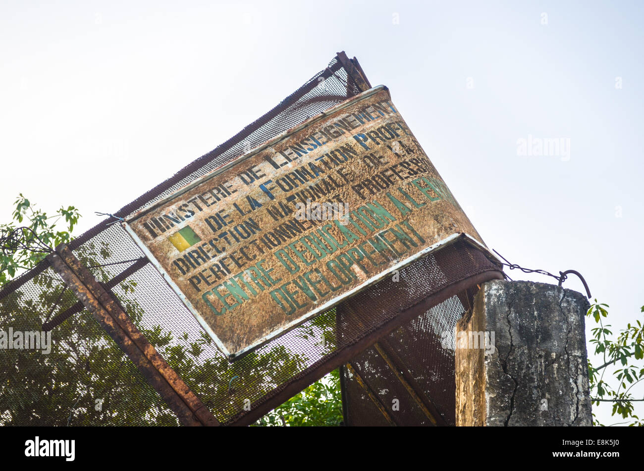 Rusty broken signe pour le ministère de l'éducation à l'usine hydroélectrique de Kinkon près de Pita, Fouta Djalon, Guinée Banque D'Images